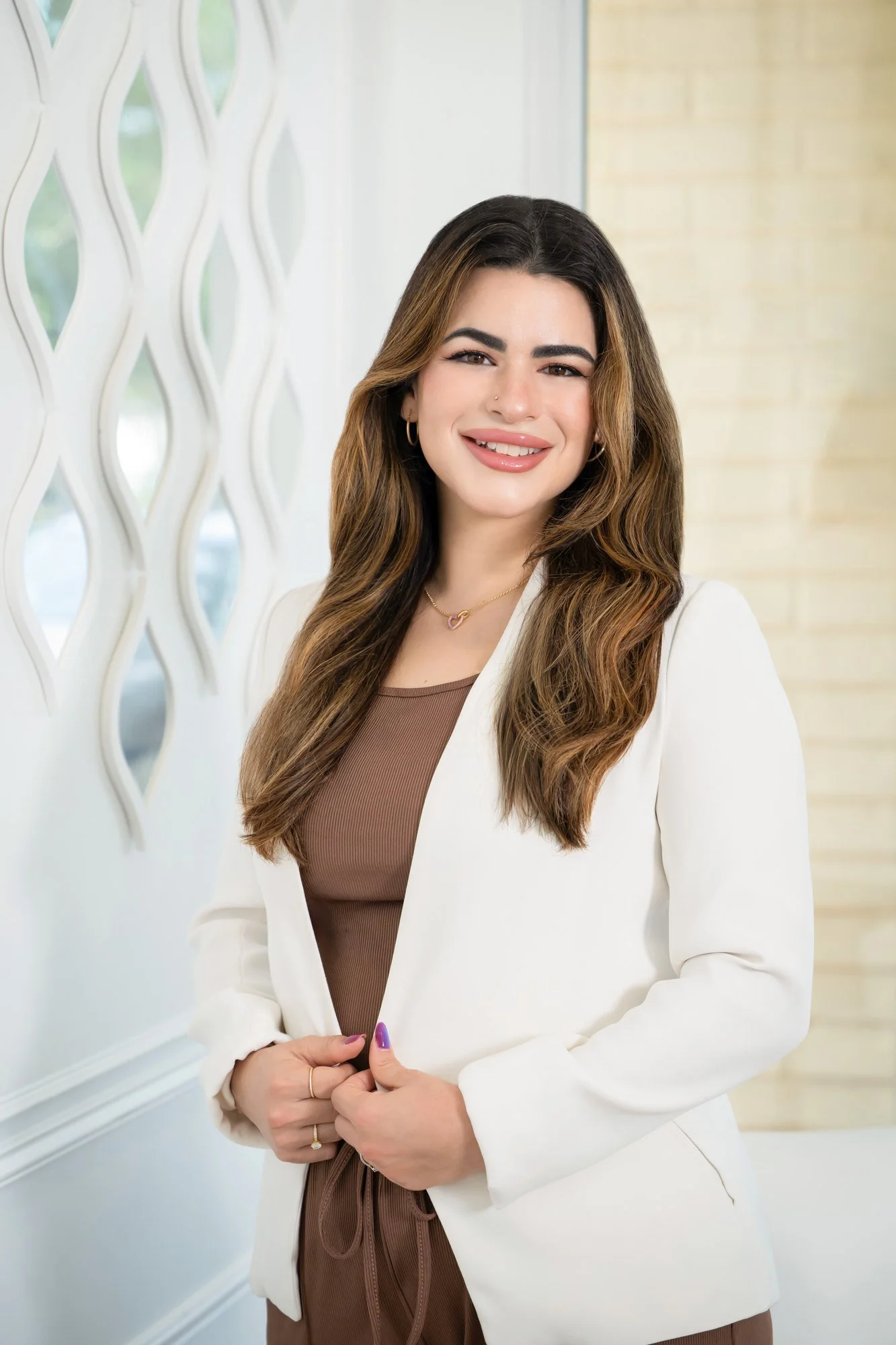 Modern branding portrait of a young businesswoman in a white blazer in a bright interior, Vasi Studio Palm Beach Gardens