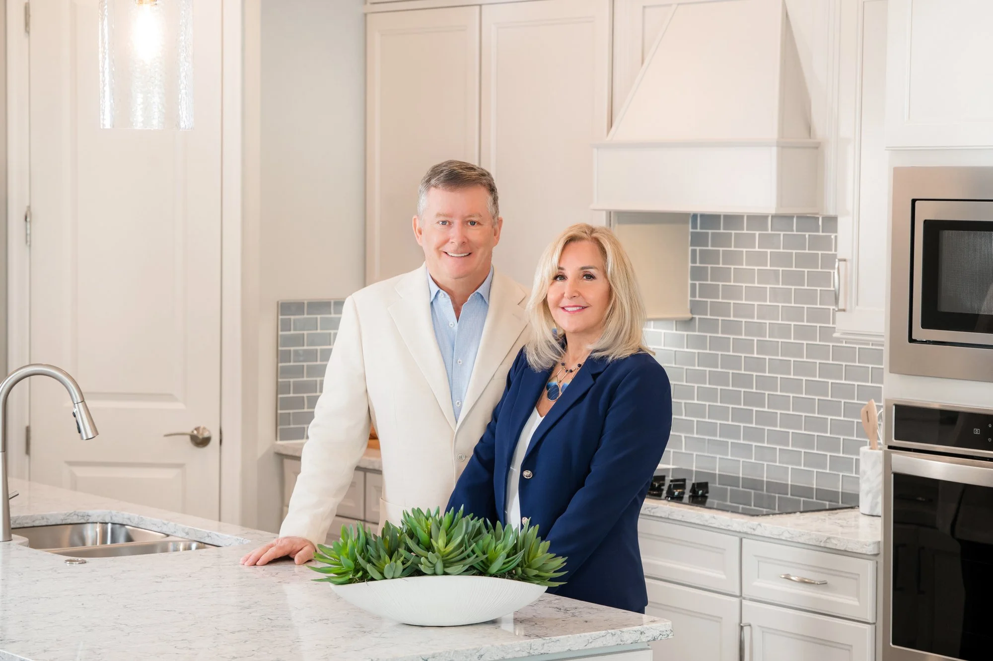 Real estate branding portrait of a couple in a modern white kitchen, lifestyle business photography by Vasi Studio