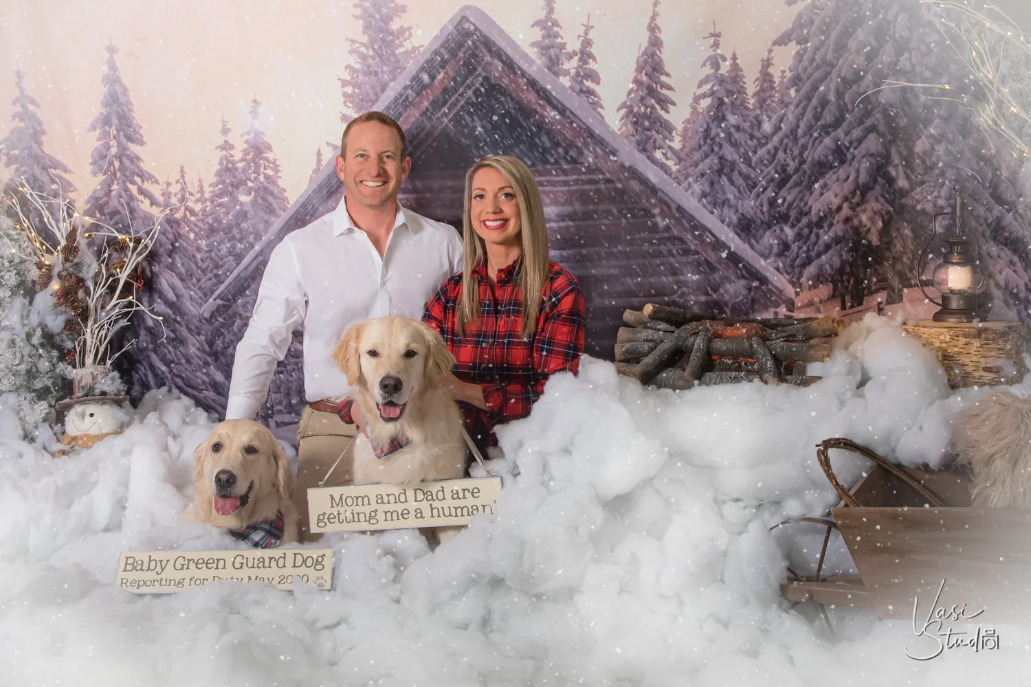Couple with two golden retrievers in a snowy winter cabin set, Christmas portrait with dogs in Palm Beach Gardens