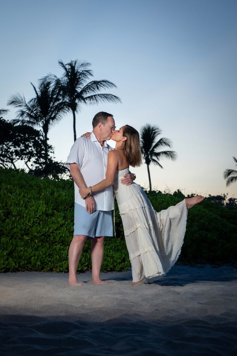 Couple kissing on the beach at sunset among palm trees, romantic couples portrait in South Florida