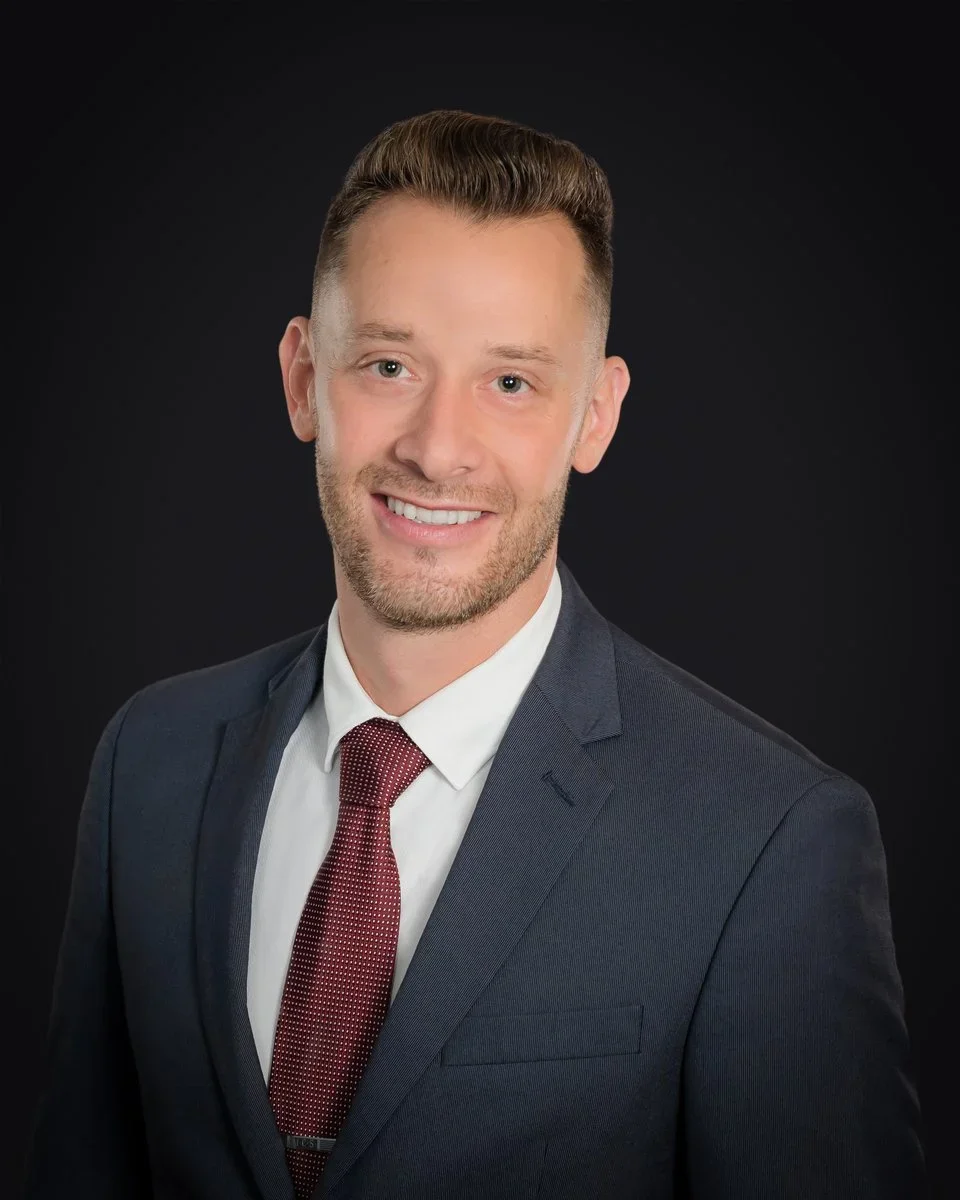 Executive headshot of a businessman in a navy suit and burgundy tie, professional business portrait by Vasi Studio in Palm Beach Gardens