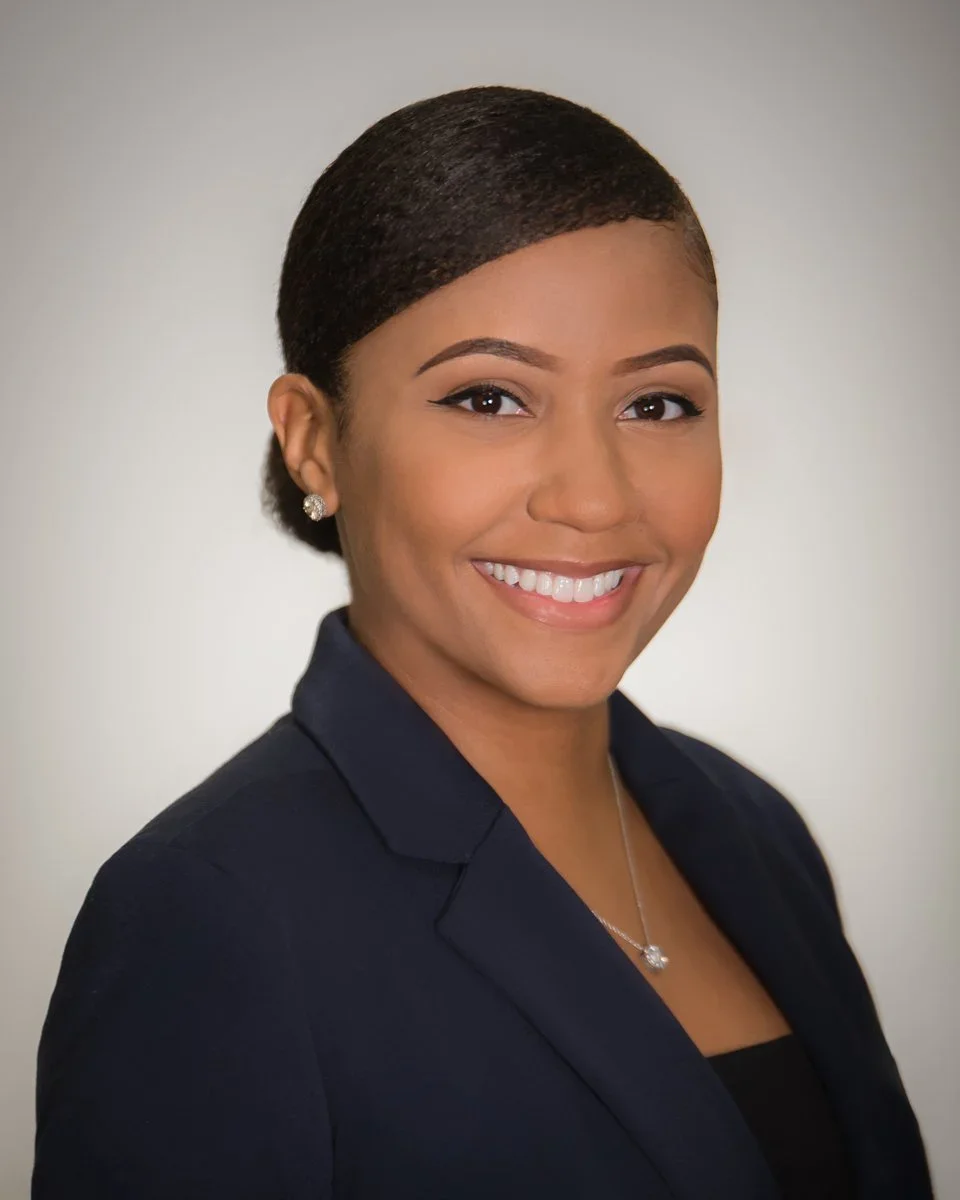 Authentic professional headshot of a smiling businesswoman in a navy blazer, real photography not AI, by Vasi Studio in Palm Beach Gardens