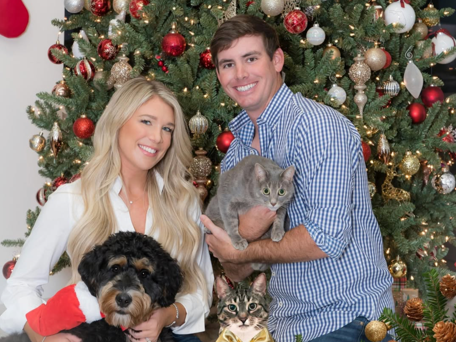 Couple with their dog and two cats in front of a decorated Christmas tree, holiday family and pet portrait in Palm Beach Gardens