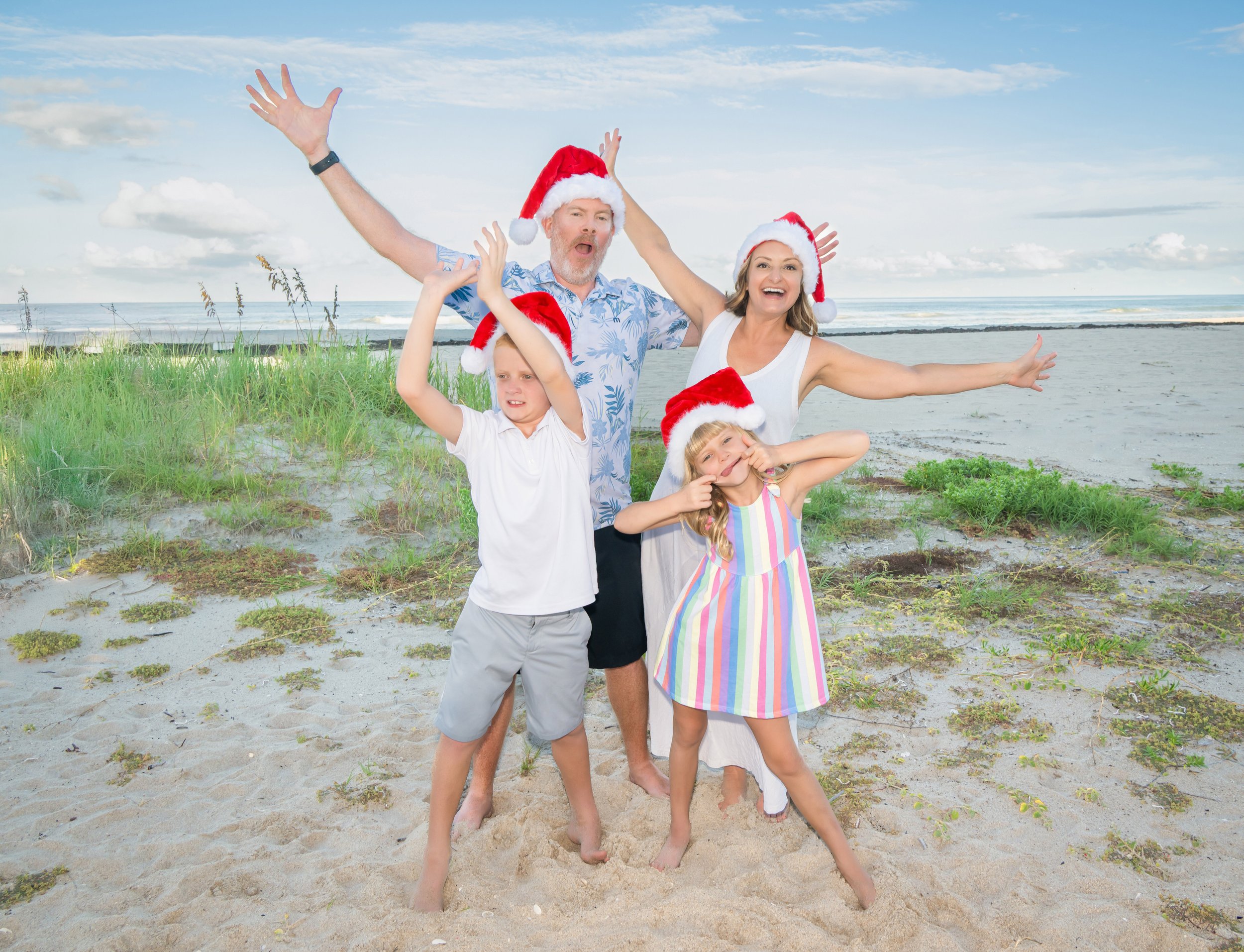 Joyful family in Santa hats on a South Florida beach, holiday family portrait by Vasi Studio Palm Beach Gardens