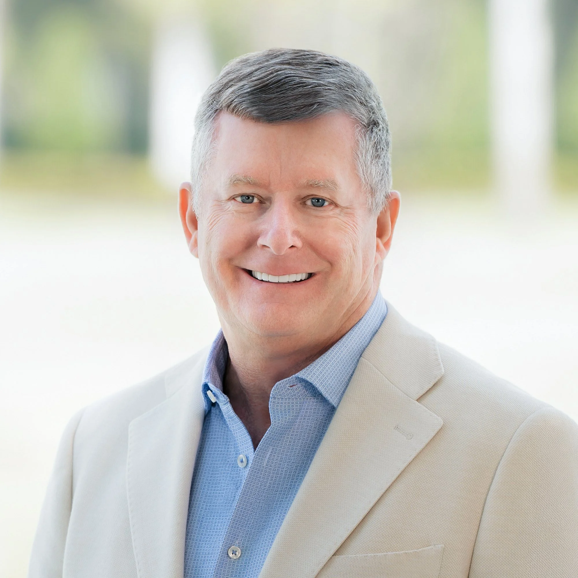 Business portrait of a smiling man in a cream blazer outdoors, executive headshots Palm Beach