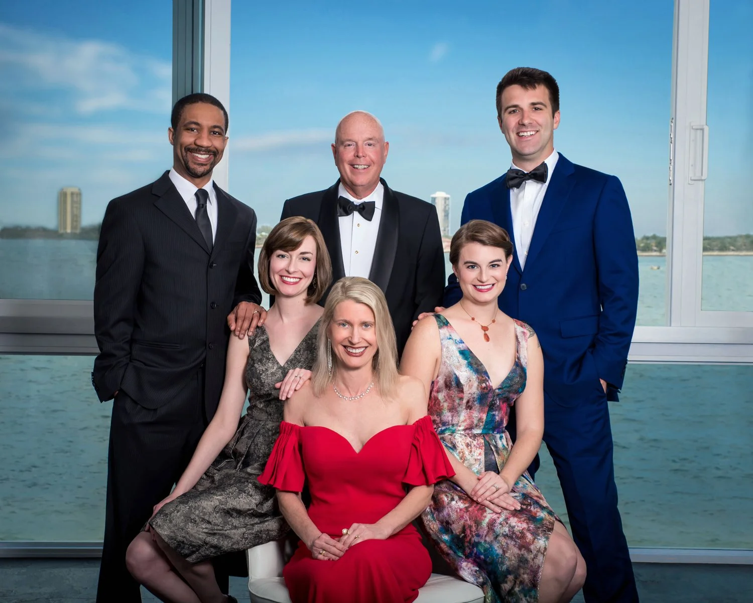Elegant group portrait in formal evening wear by a waterfront window, event and family photography Palm Beach