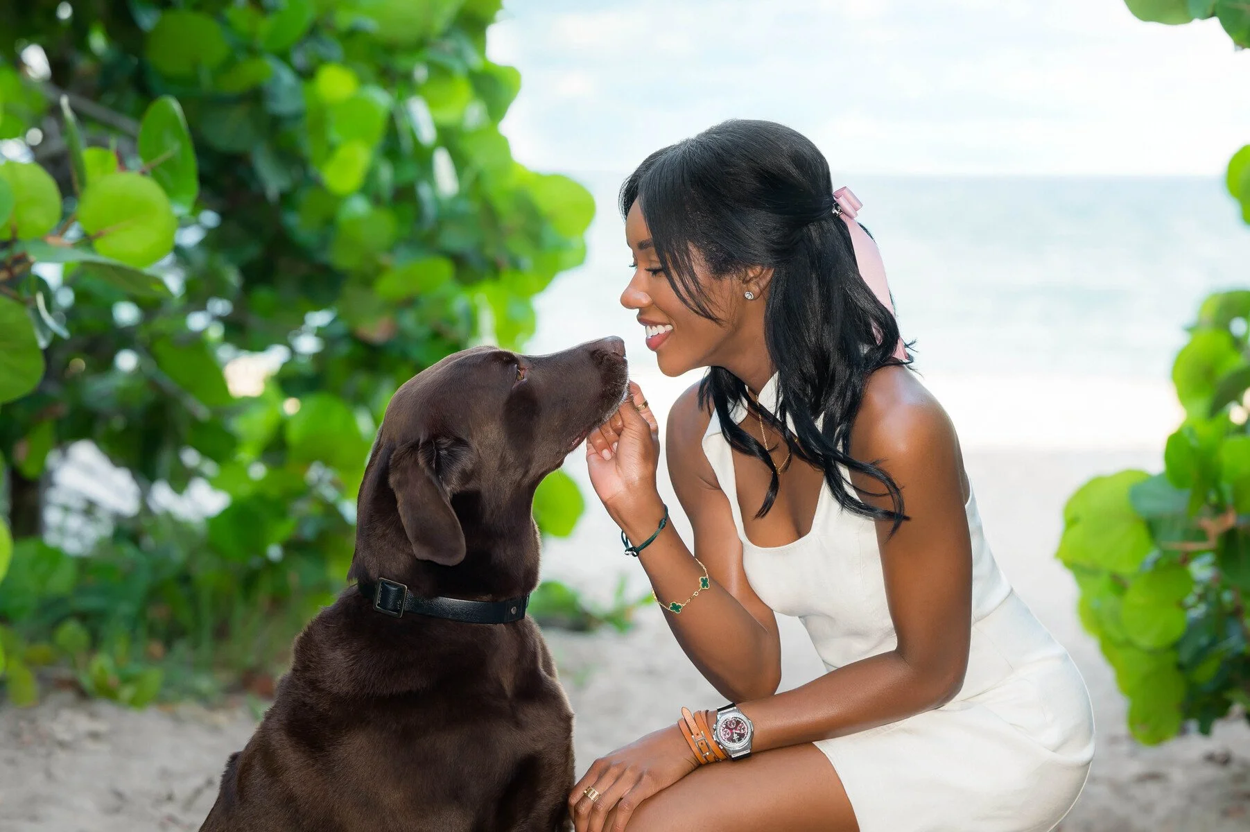 Woman sharing a sweet moment with her chocolate Labrador on the beach, person and pet portrait by Vasi Studio in Palm Beach County
