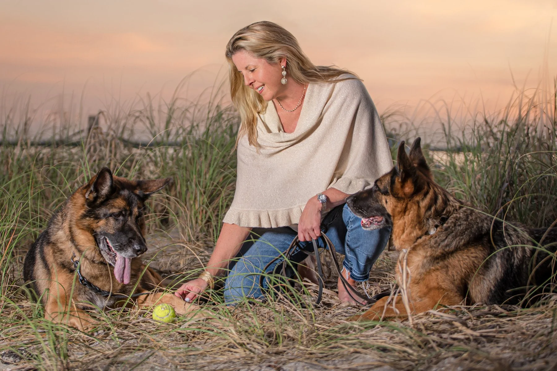 Woman with her two German Shepherds in the beach dunes at sunset, pet portrait by Vasi Studio, Palm Beach Gardens