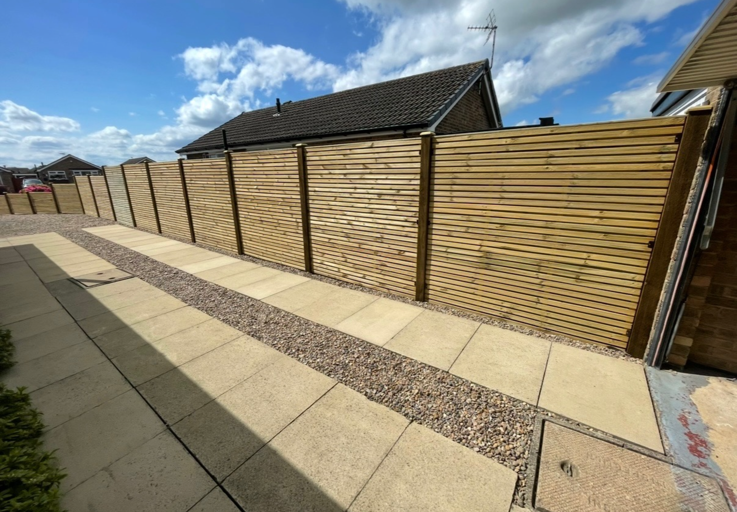 Double slatted pressure treated contemporary fence installation, fence install, staggered height fence, driveway fence, long garden fence