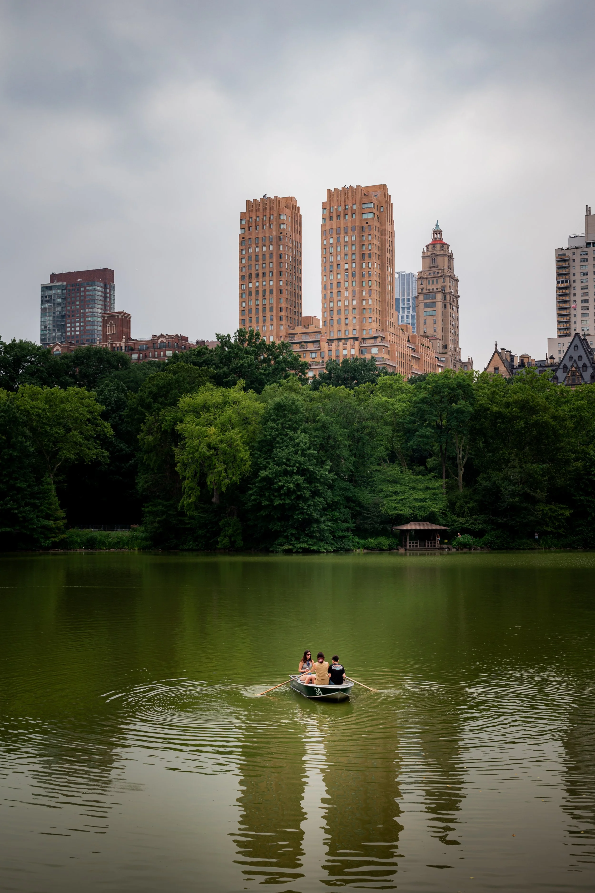 couple and family enjoying their vacation in New York City, Central Park at the lake with boat.
