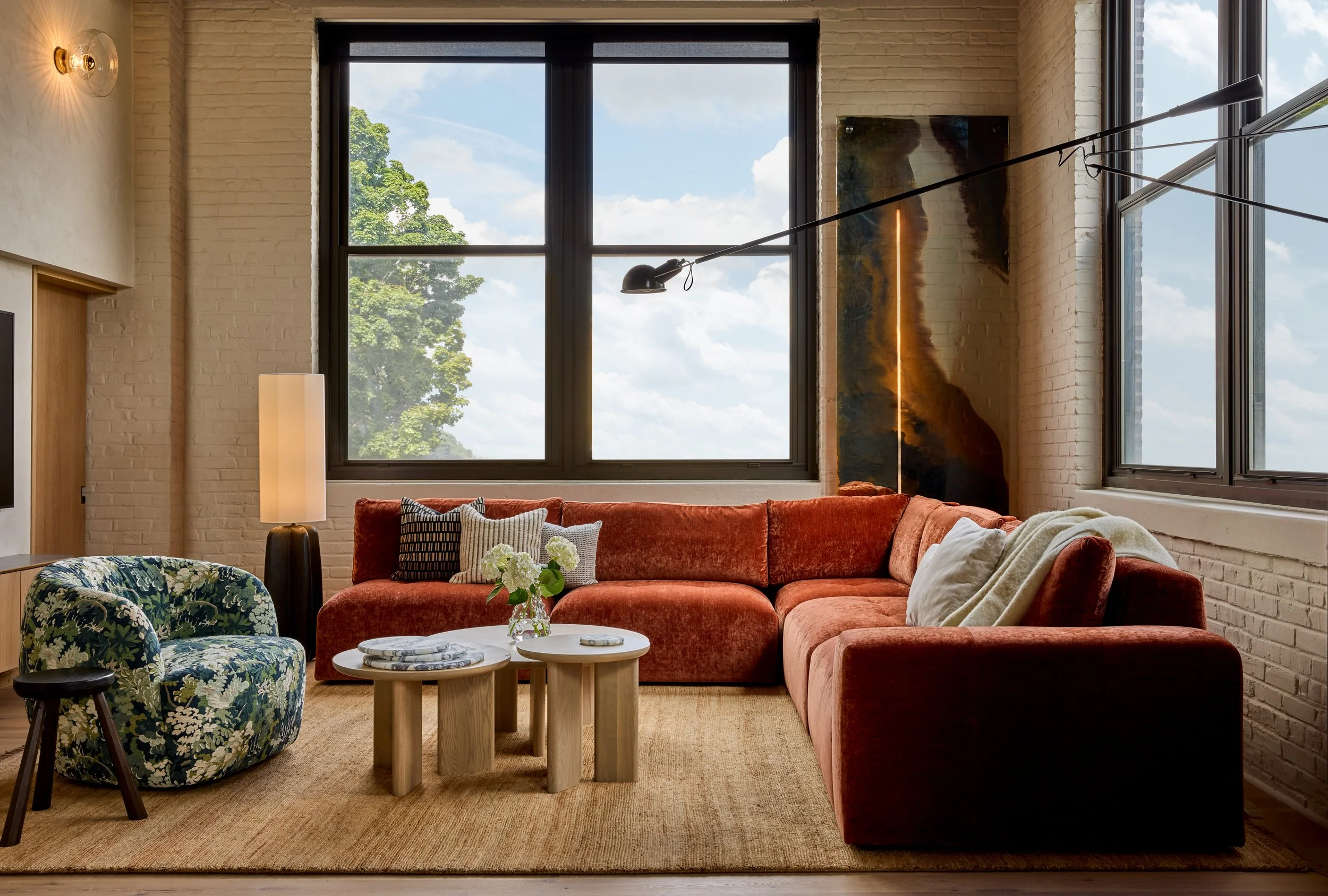luxurious living room design with orange velvet sectional and tapestry print arm chair