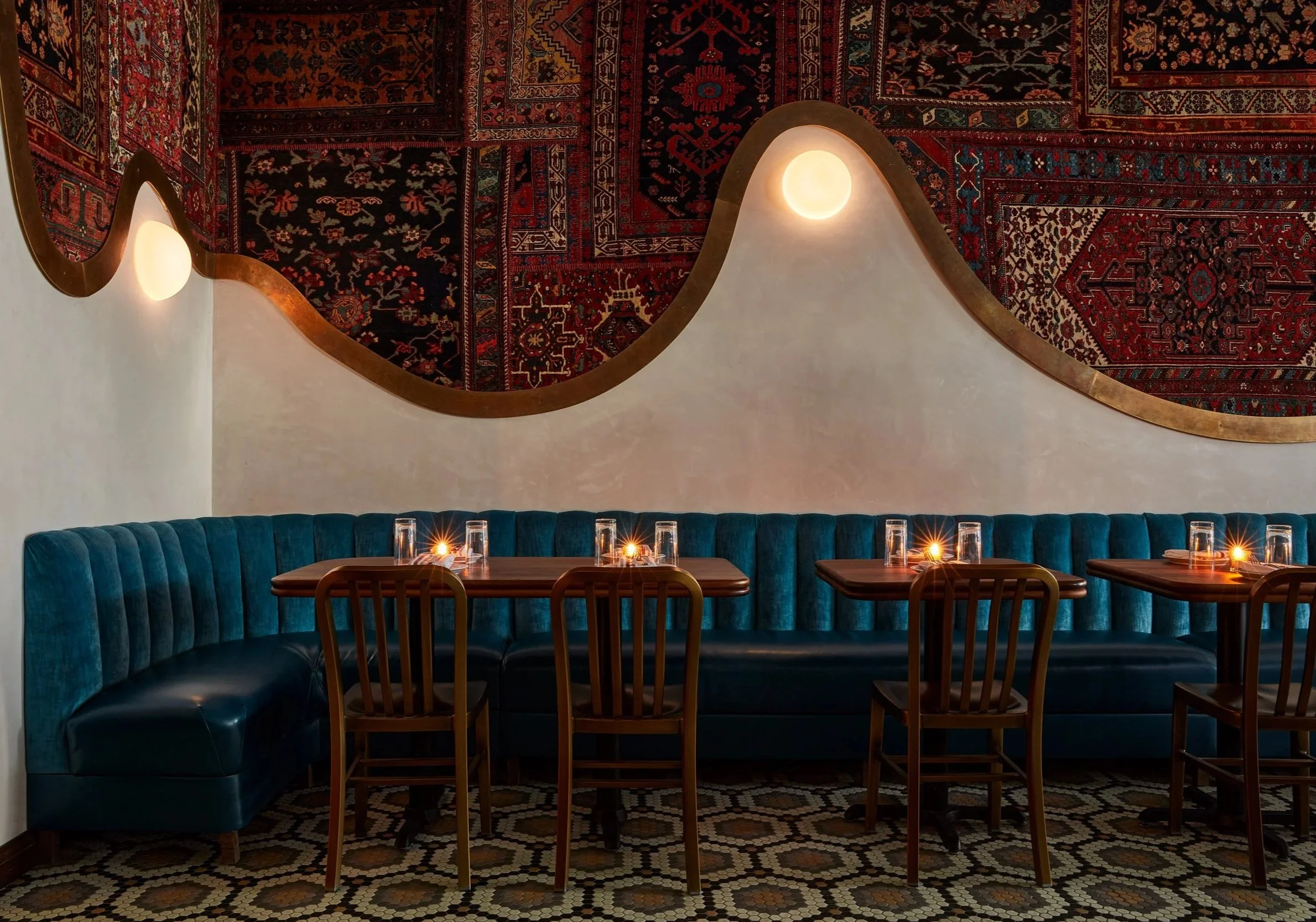lux restaurant design with teal belvet banquette and curvey persial wall rugs