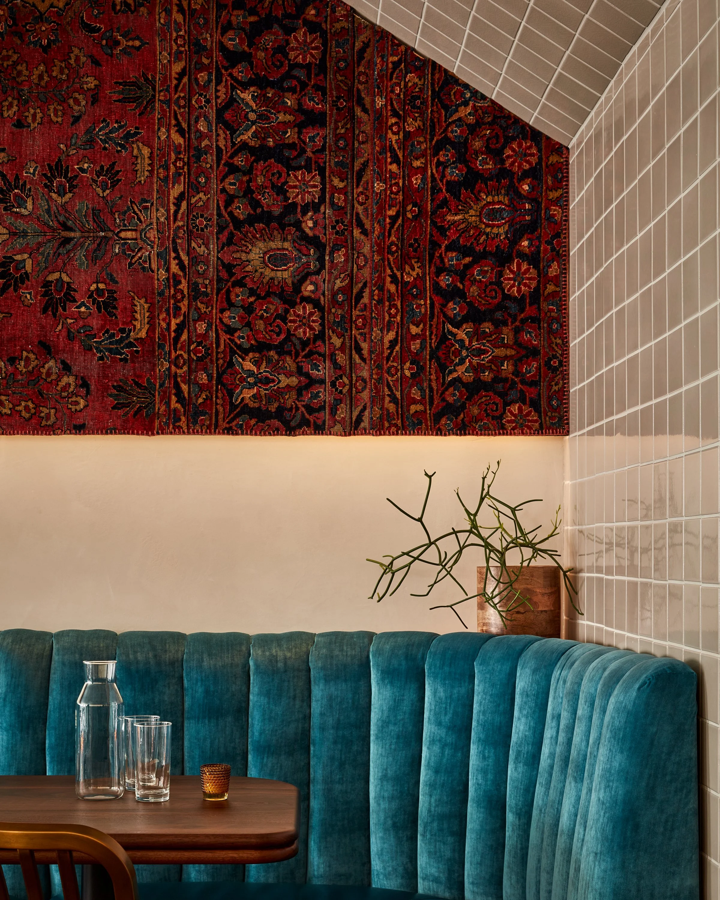 detail of team banquette modern fireclay tile and a red persian wall rug