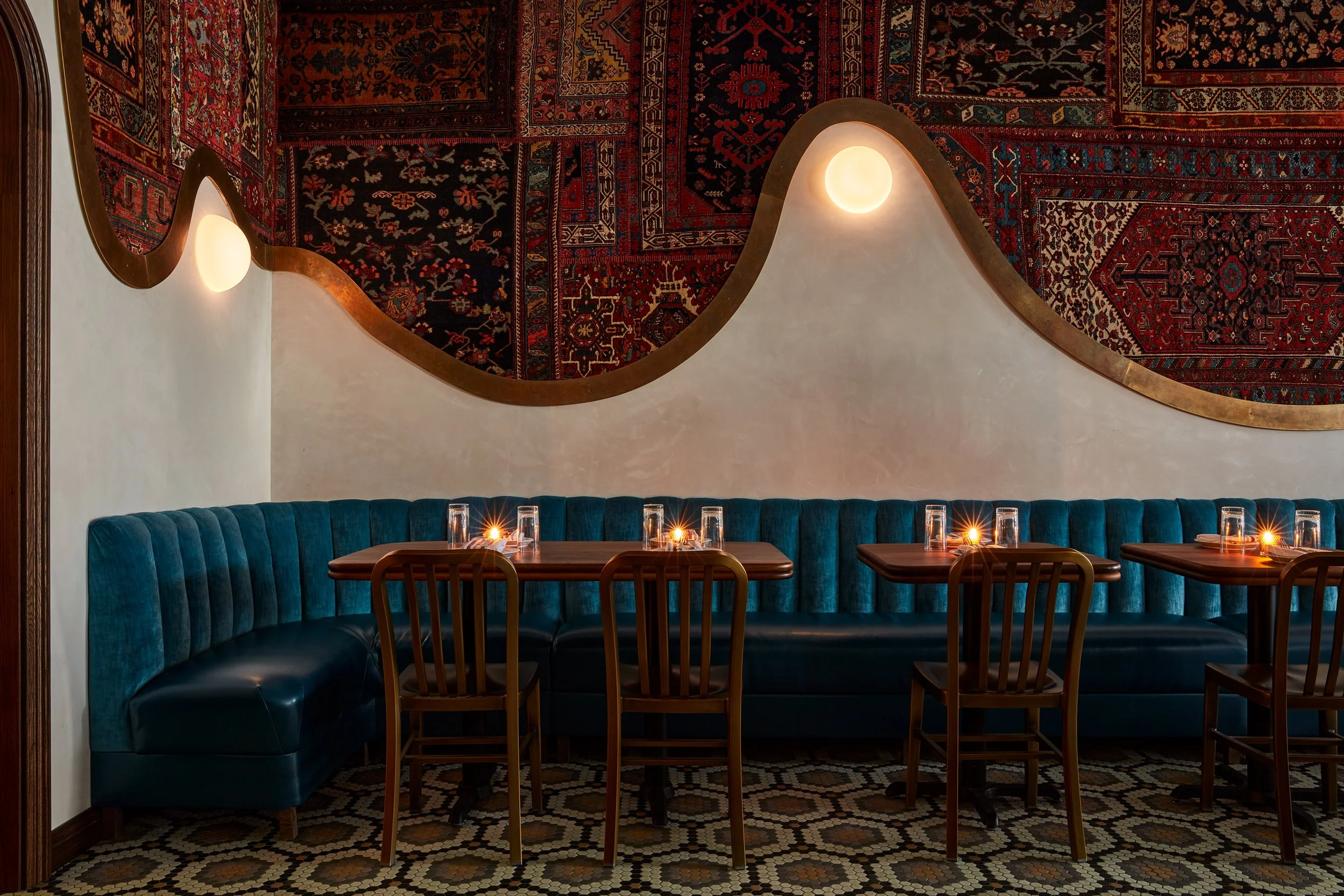 restaurant's first floor banquettes wood tables and persian rug mural