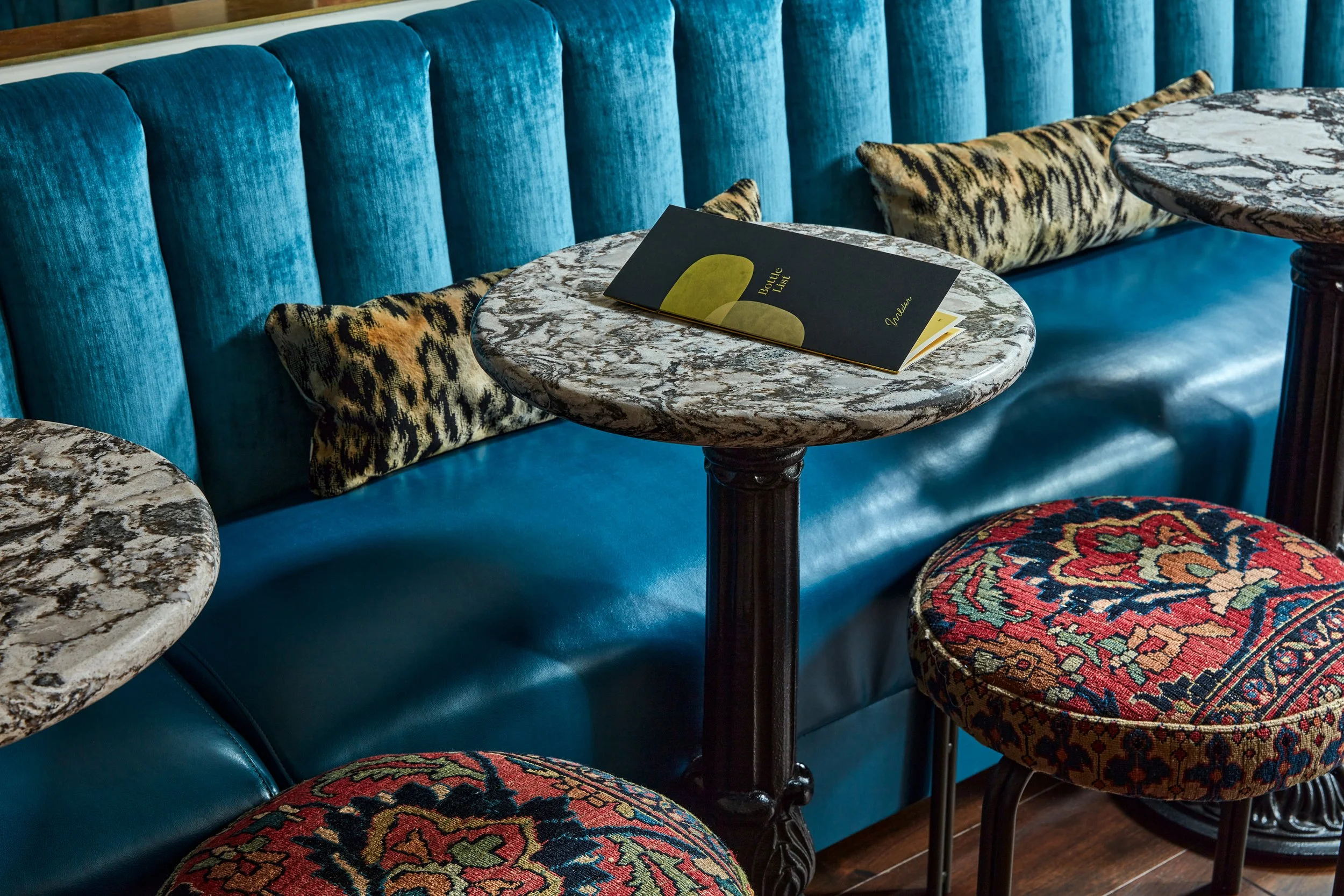 close up of teal banquette and custom stools upholstered in turkish rug