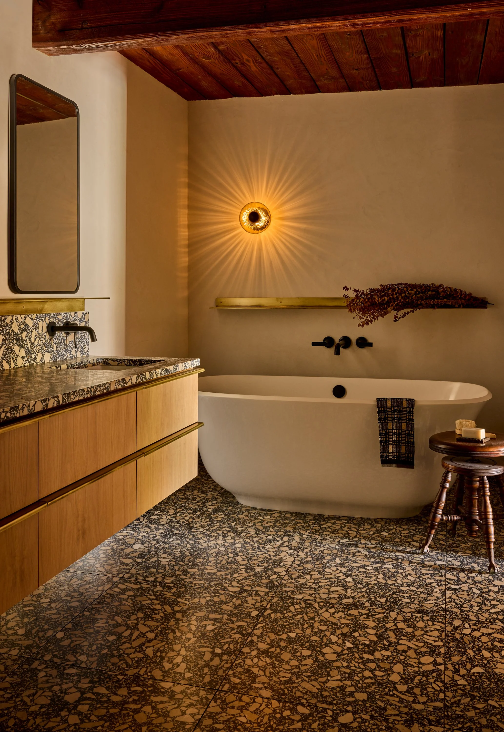 primary bathroom showing floating bath tub and black and tan terrazzo floors