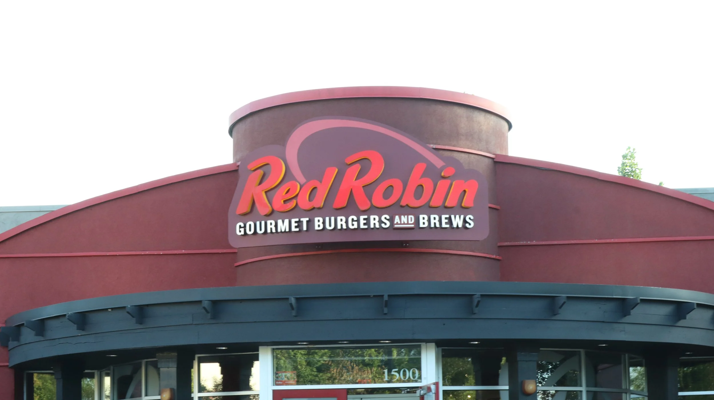 Red Robin restaurant sign with the text "Gourmet Burgers and Brews" on a building facade.