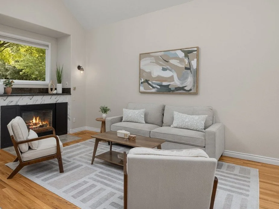 Vaulted living room with a fireplace, abstract art and accent chairs