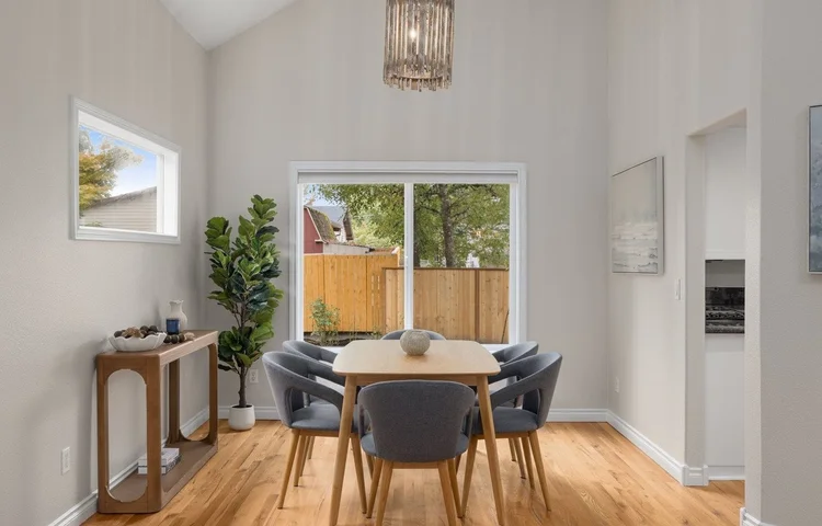 Dining room with a tall window, chandelier and round table