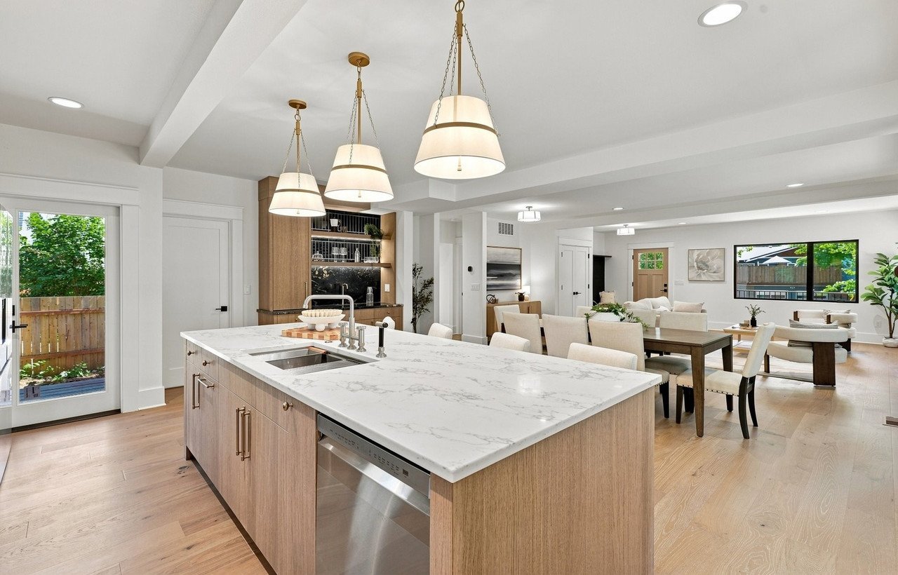 New-construction kitchen island with marble counters and the dining area beyond