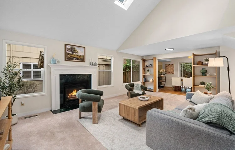 Cozy vaulted living room with a fireplace and sage boucle chairs