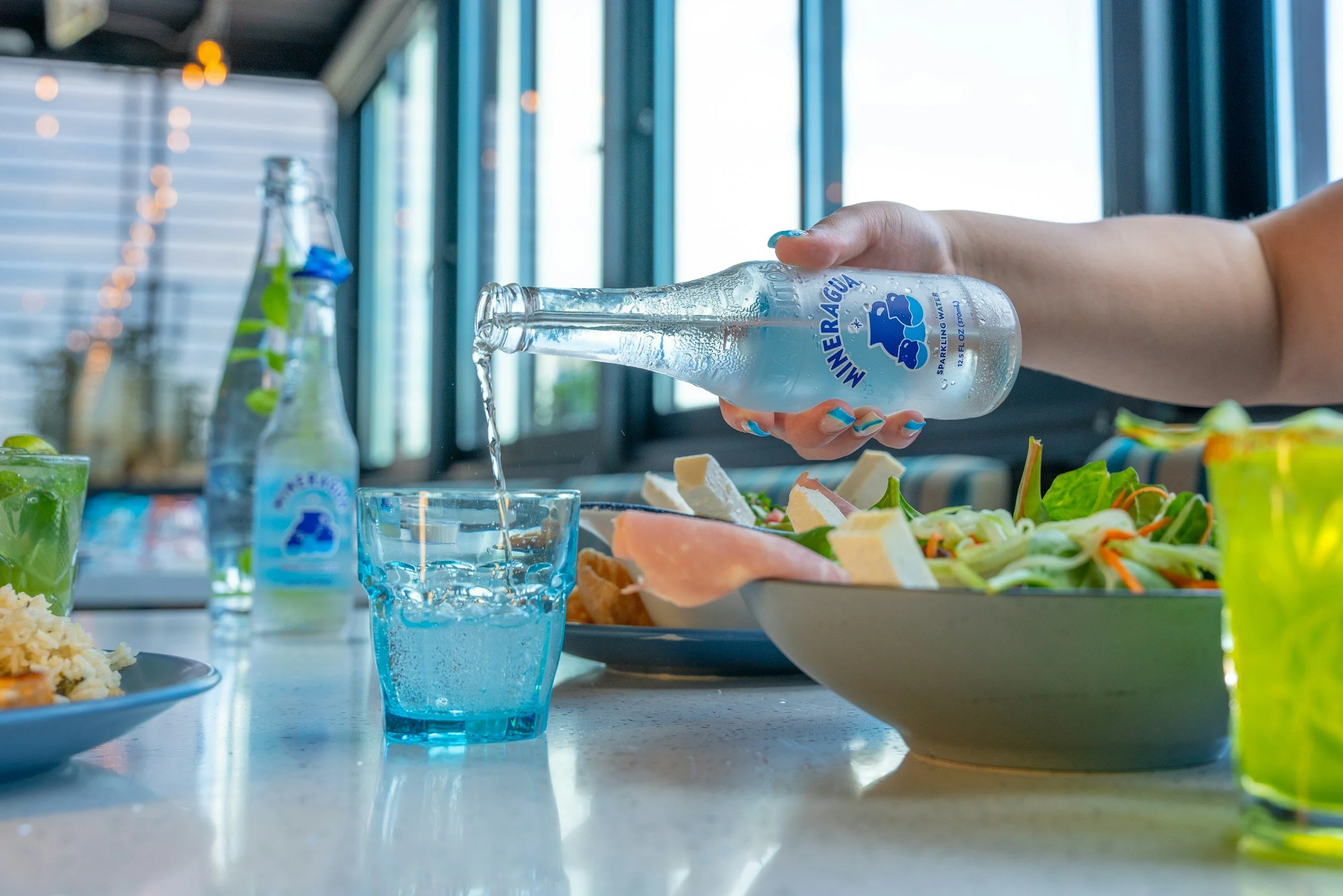 Pouring water into glasses at a meal, supporting hydration and nutrition for POTS