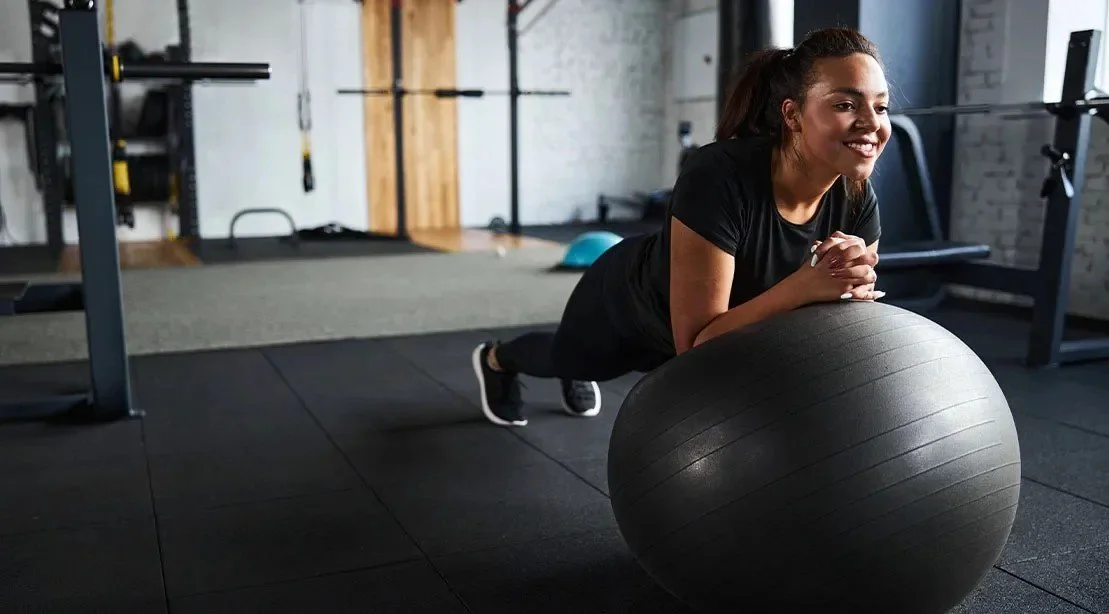 Woman doing core exercise on a stability ball during rehab