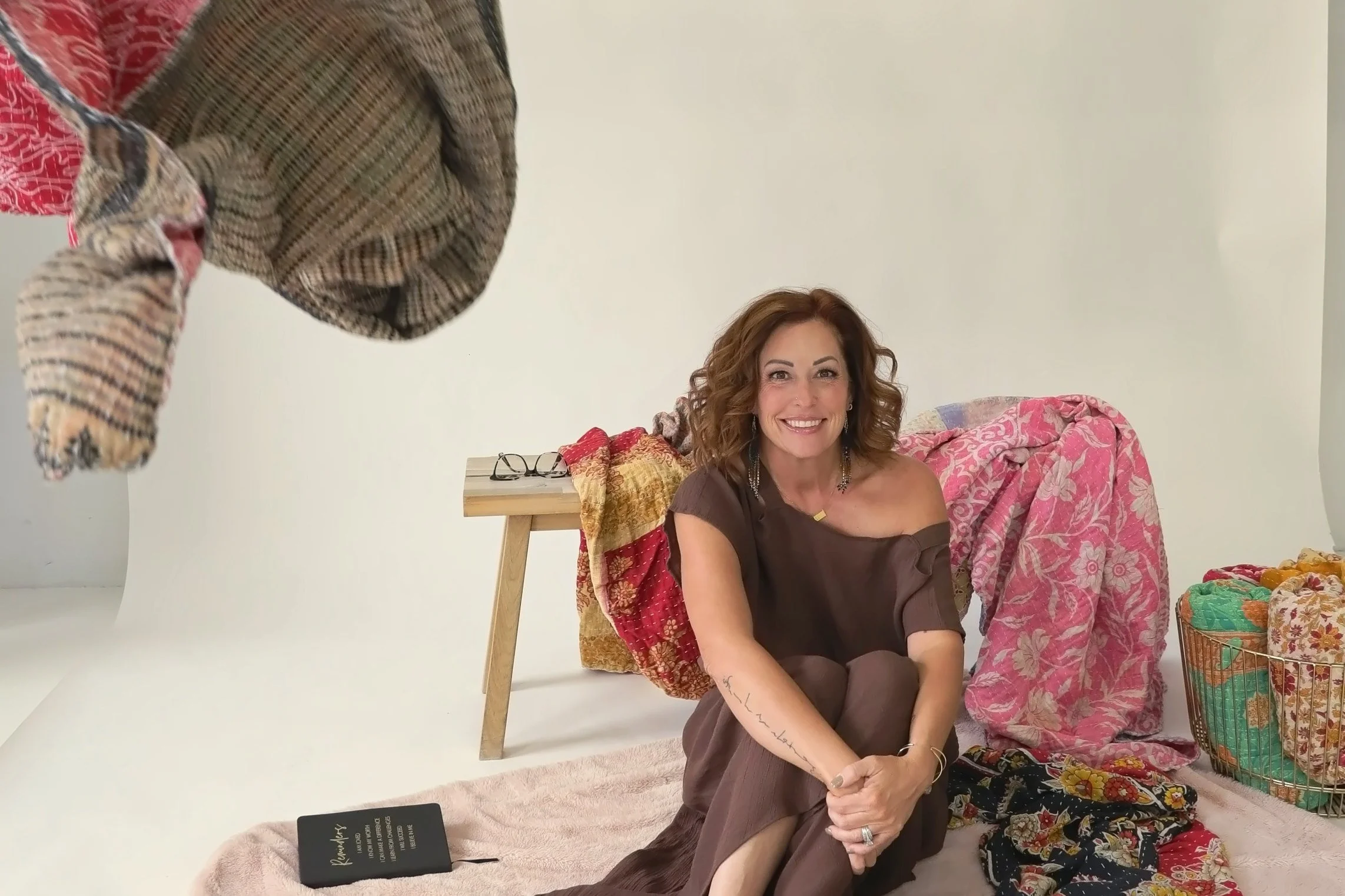 Wende Valentine smiling as kantha blankets fall around her
