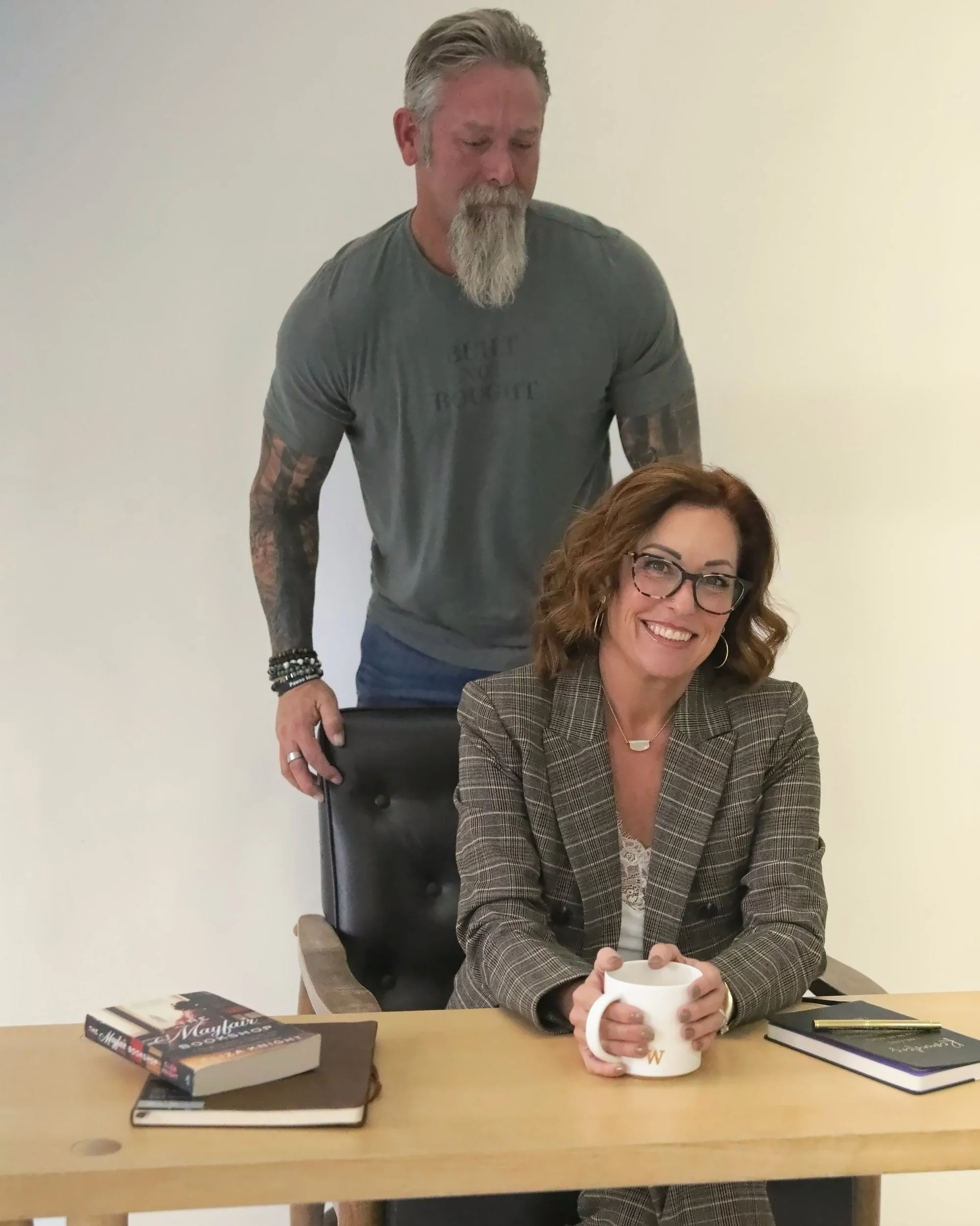 Wende Valentine at her desk with Steve standing behind her chair