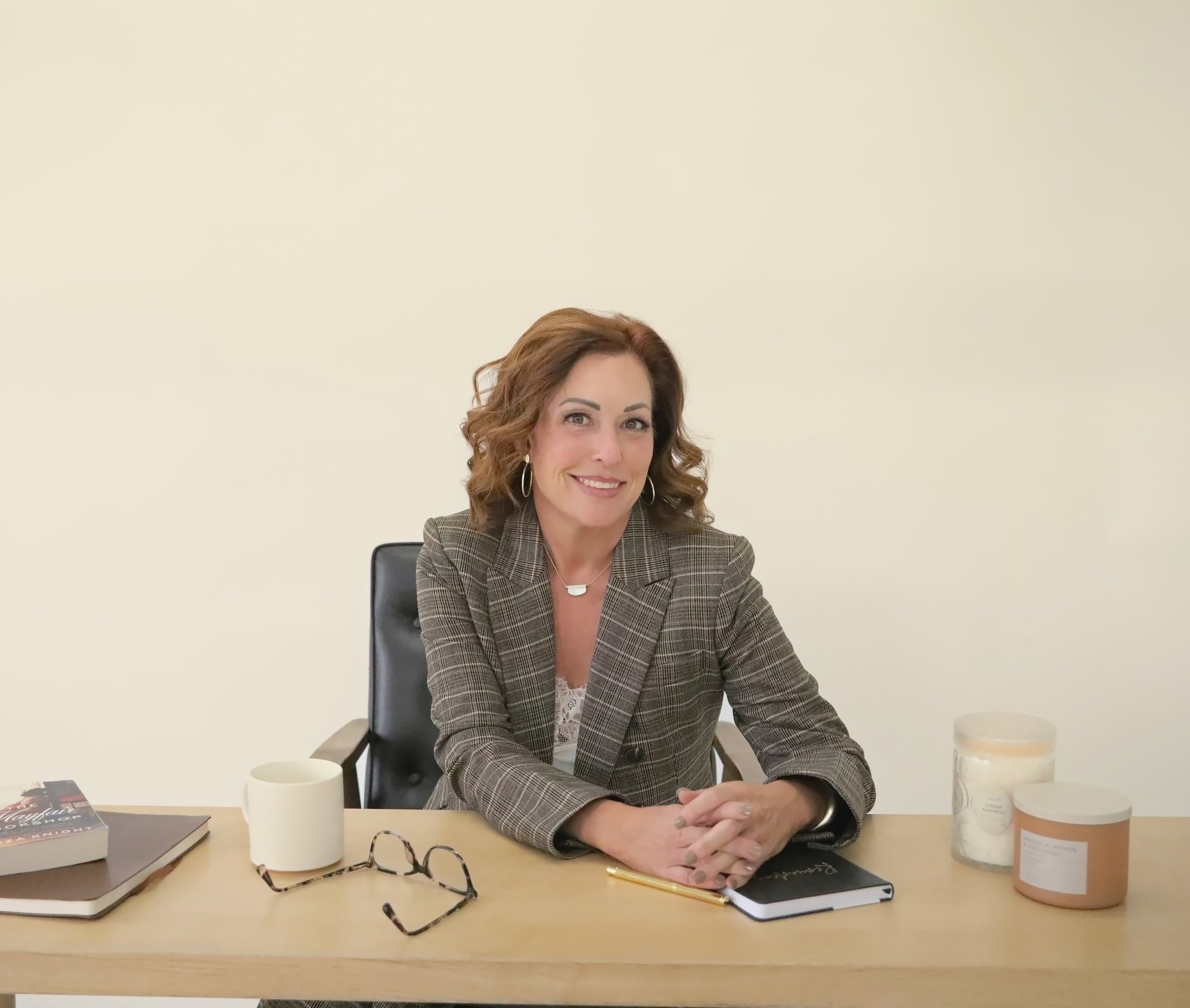Wende Valentine at her desk, hands folded, smiling