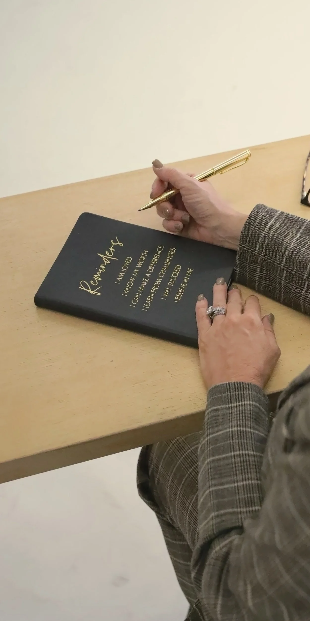 Wende Valentine writing in her journal with a gold pen