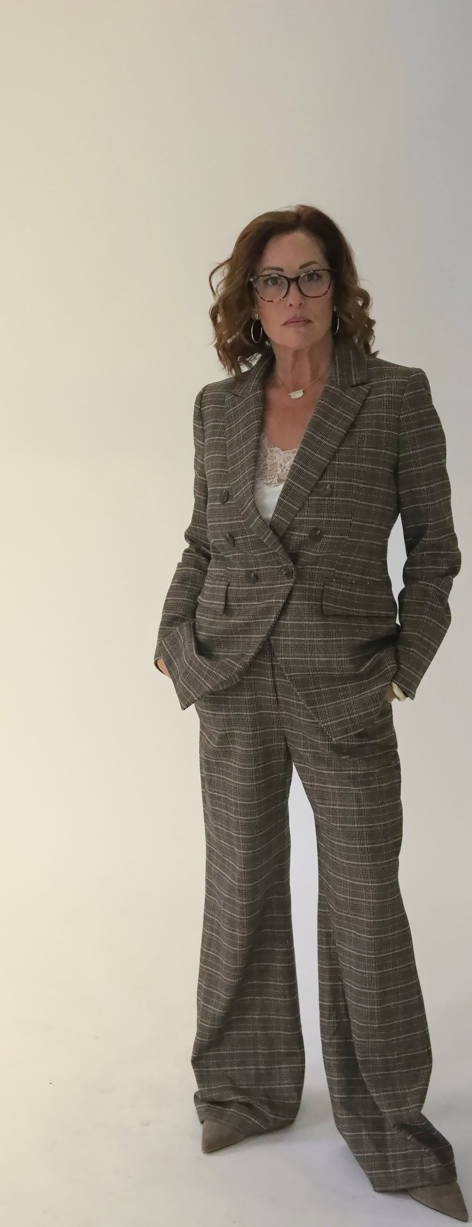 Wende Valentine standing in a plaid suit, hands in pockets