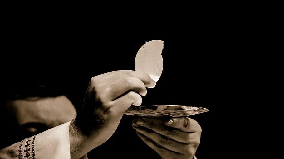 A person holding a plate with a piece of eggshell, possibly during a ritual or celebration