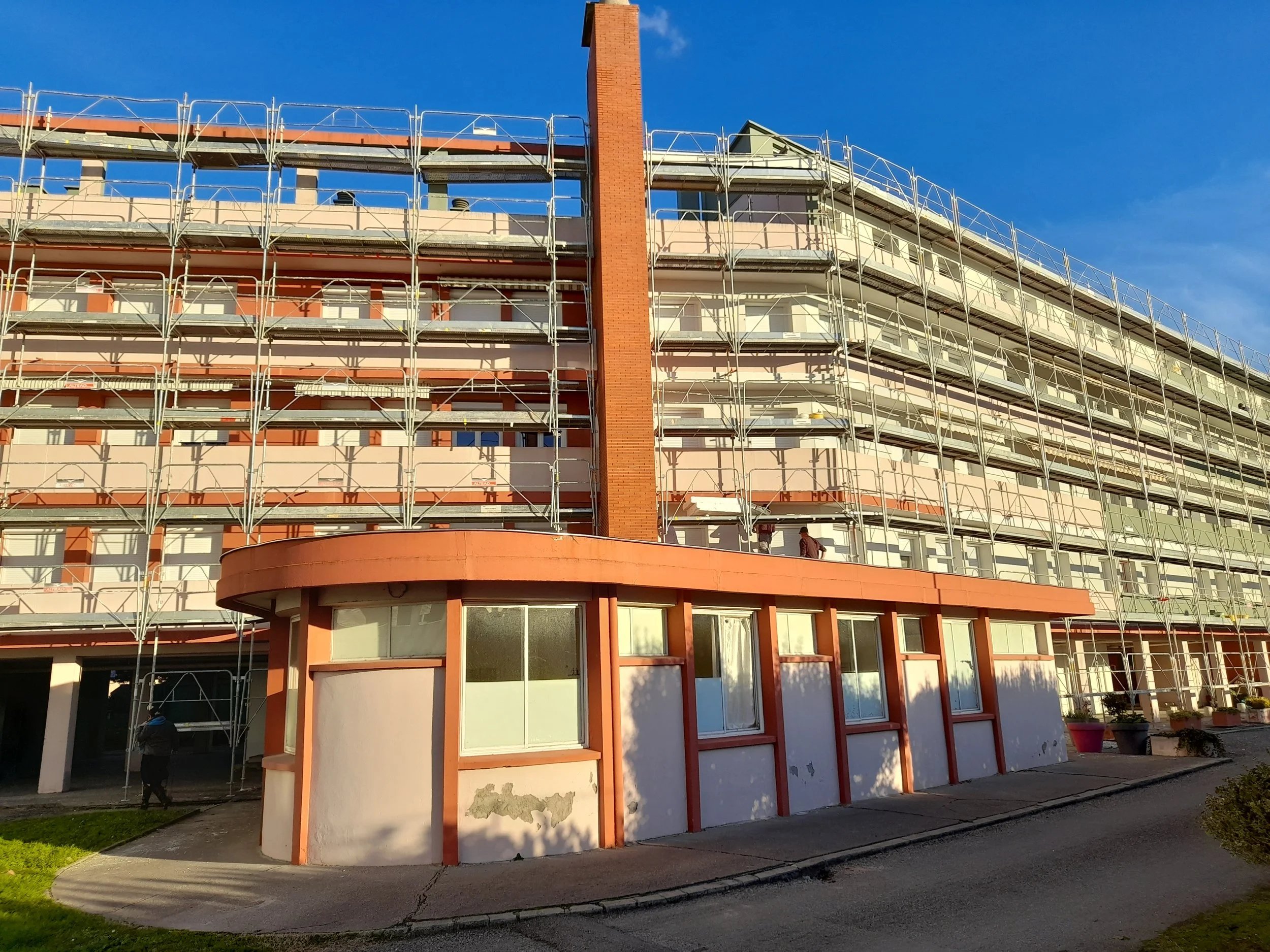Un grand bâtiment en cours de rénovation avec des échafaudages.