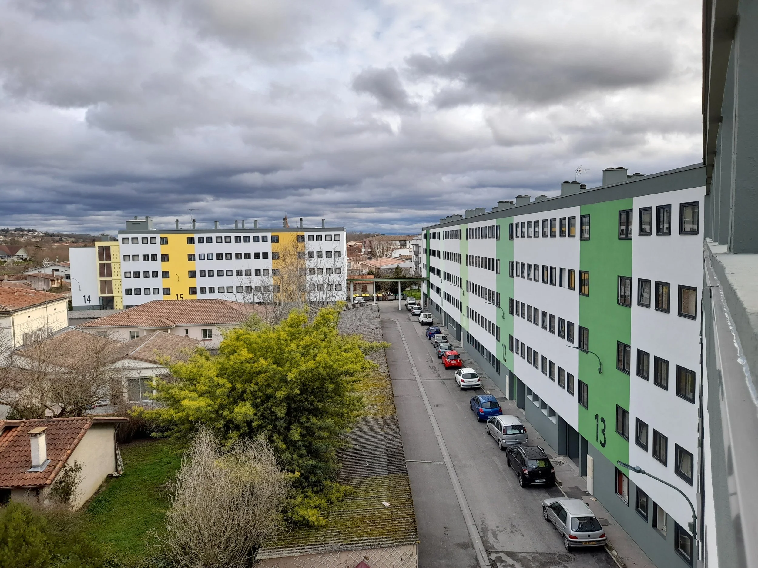 Un immeuble résidentiel rénové avec une ITE colorée et des fenêtres anthracites.