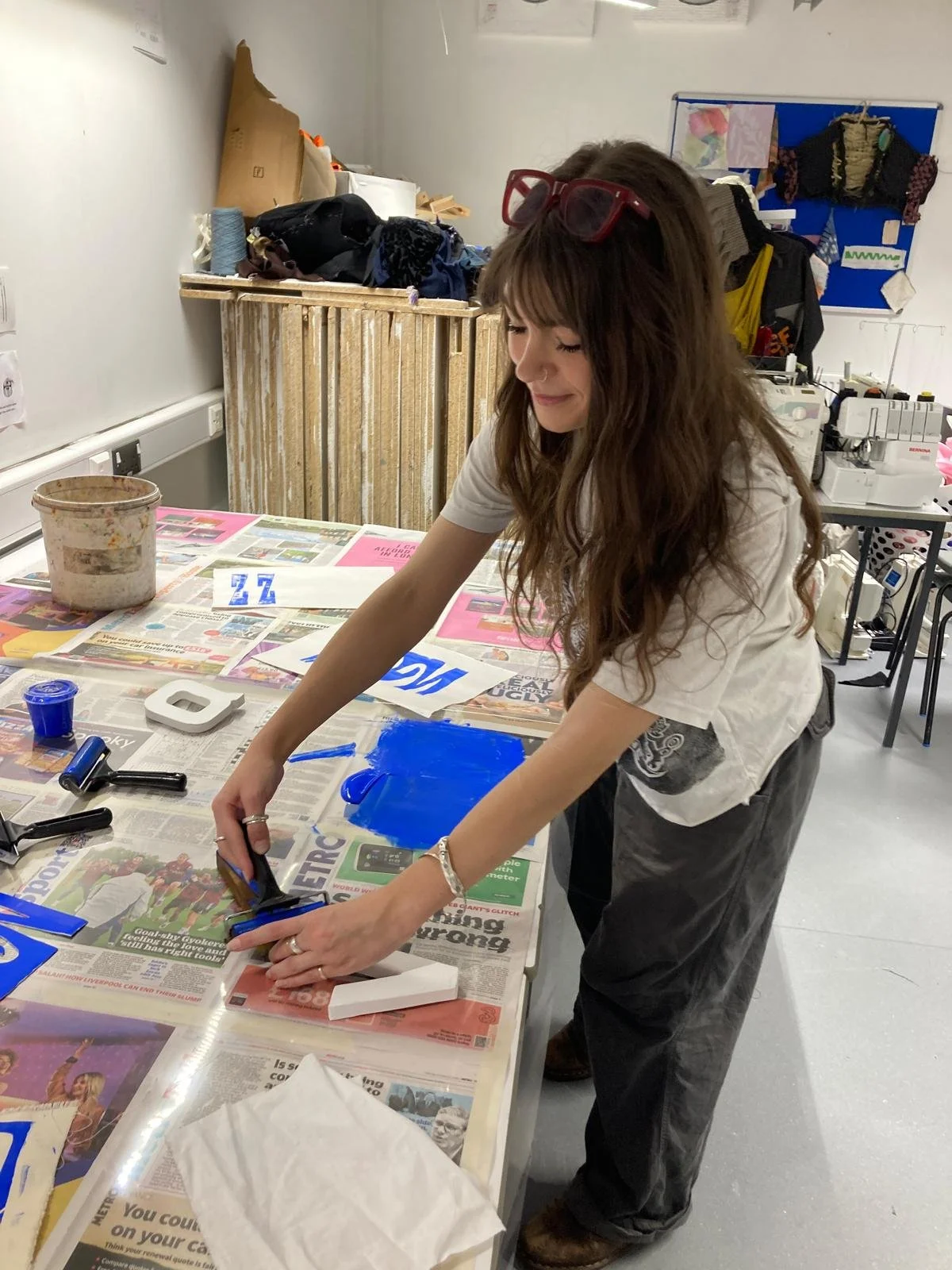 Showing the students the hands-on printing techniques for block printing onto fabric and paper.
