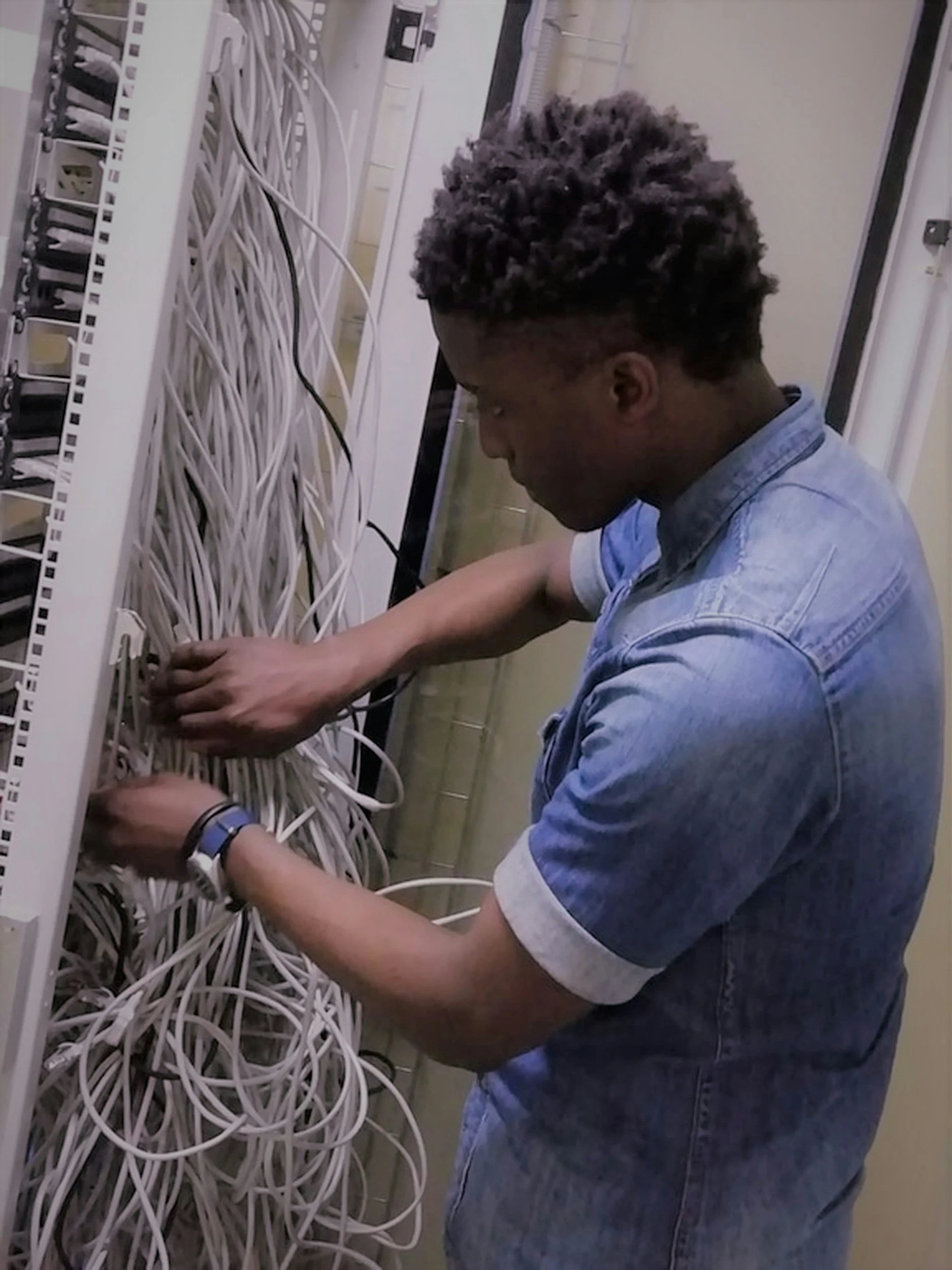 IT engineer installing network cabling in a comms cabinet
