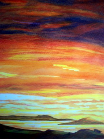 A colorful sunset with vibrant hues of red, orange, yellow, and blue in the sky over a silhouetted landscape.