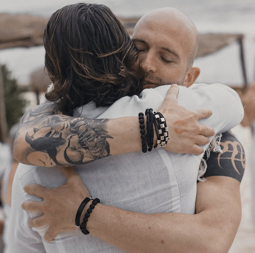 Tattooed couple embracing in a close hug outdoors