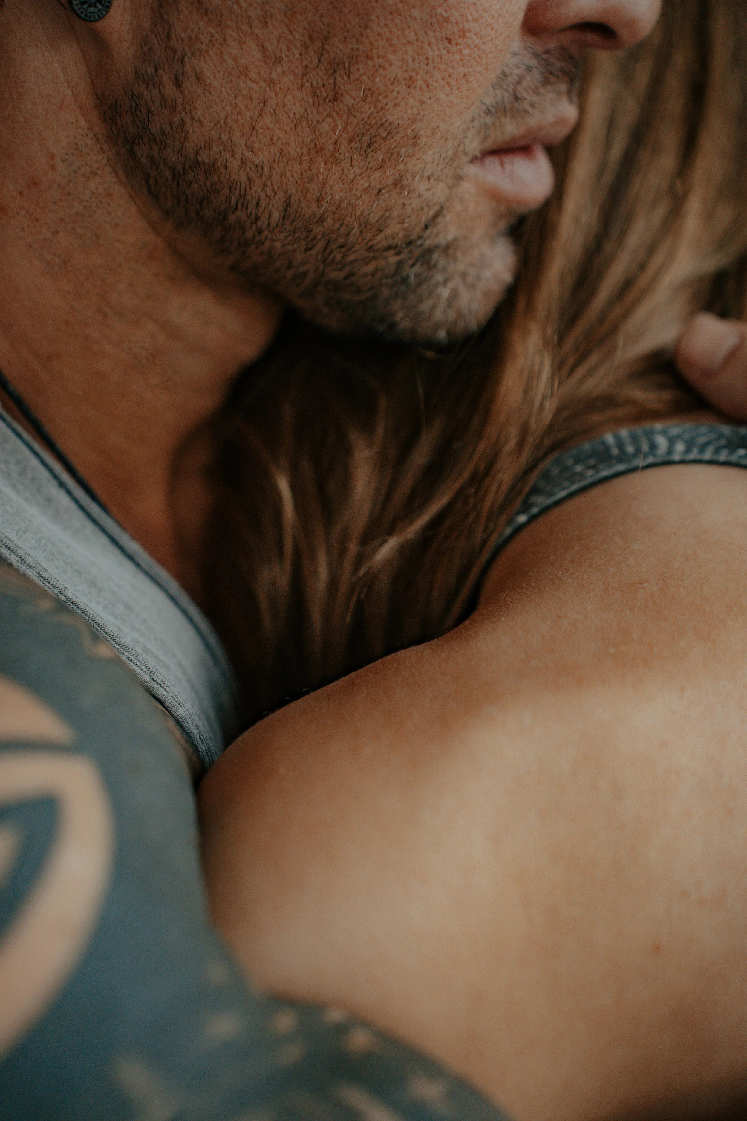 Close-up of a bearded man kissing a woman with long brown hair