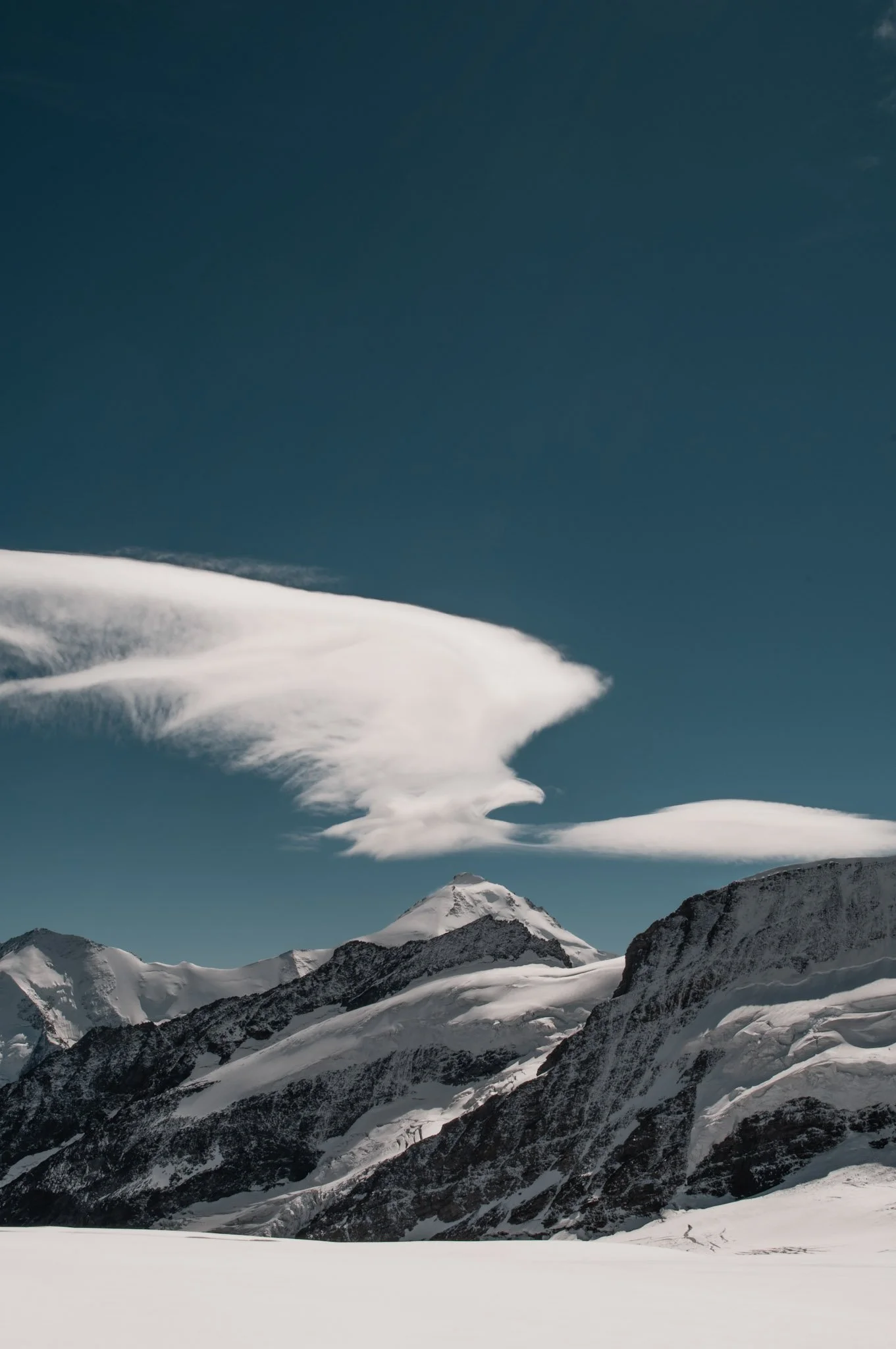 Snow-covered mountains under a partly cloudy sky.