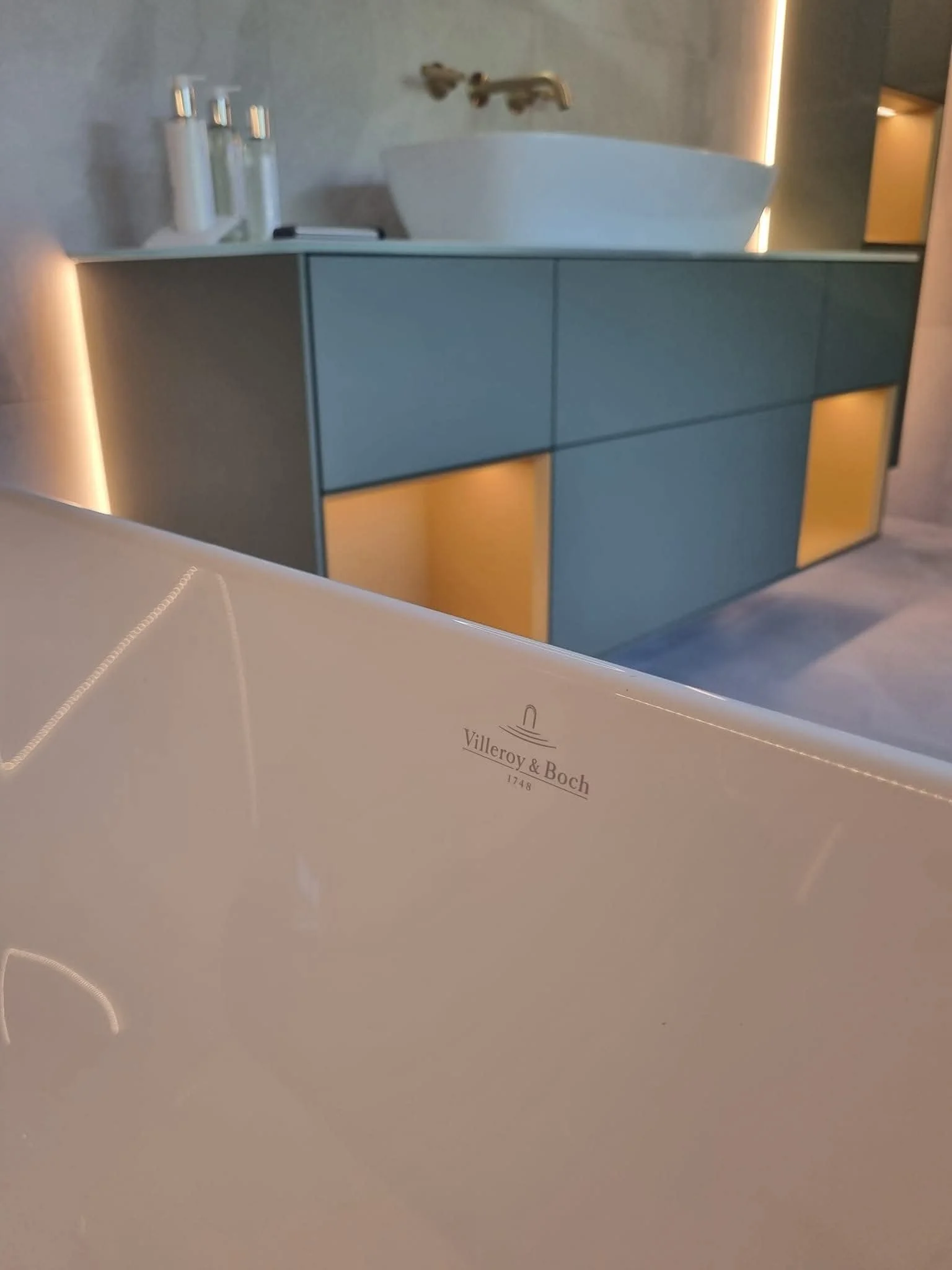 Contemporary bathroom renovation by Oliver Francis Interiors, featuring a Villeroy & Boch bathtub, floating vanity unit, vessel basin and warm integrated lighting.