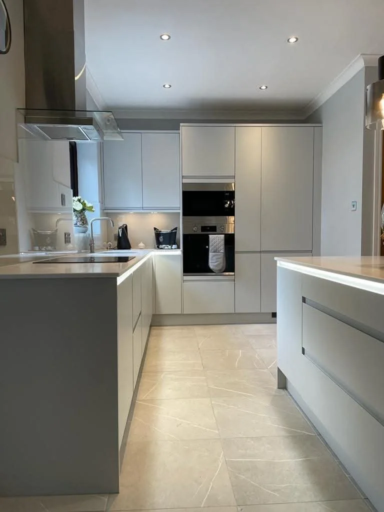 Completed kitchen renovation in by Oliver Francis Interiors, with modern fitted cabinetry, integrated appliances, kitchen island and tiled flooring.