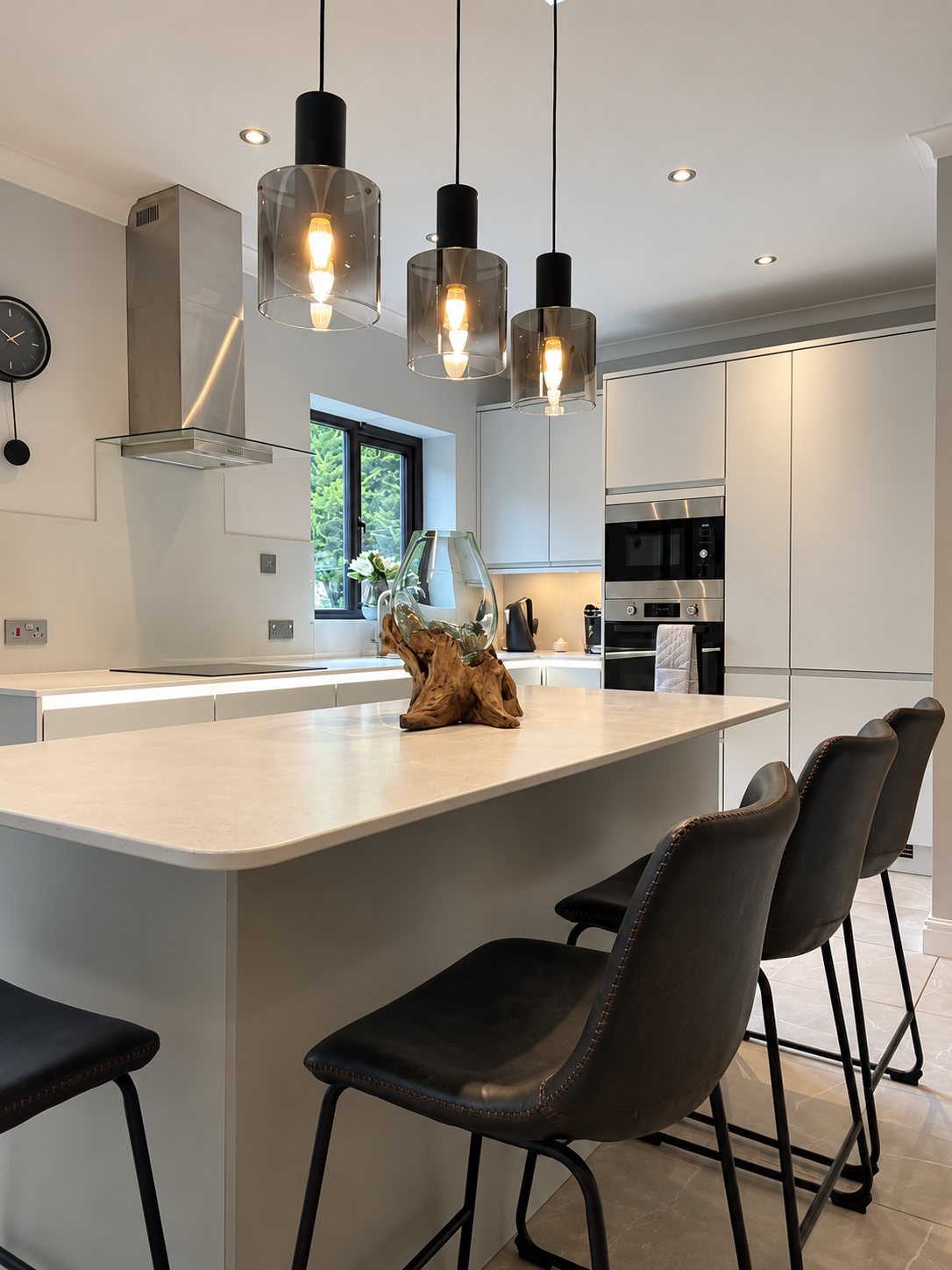 Modern kitchen design and installation in Waterhead by Oliver Francis Interiors, featuring a large kitchen island, integrated appliances and pendant lighting.