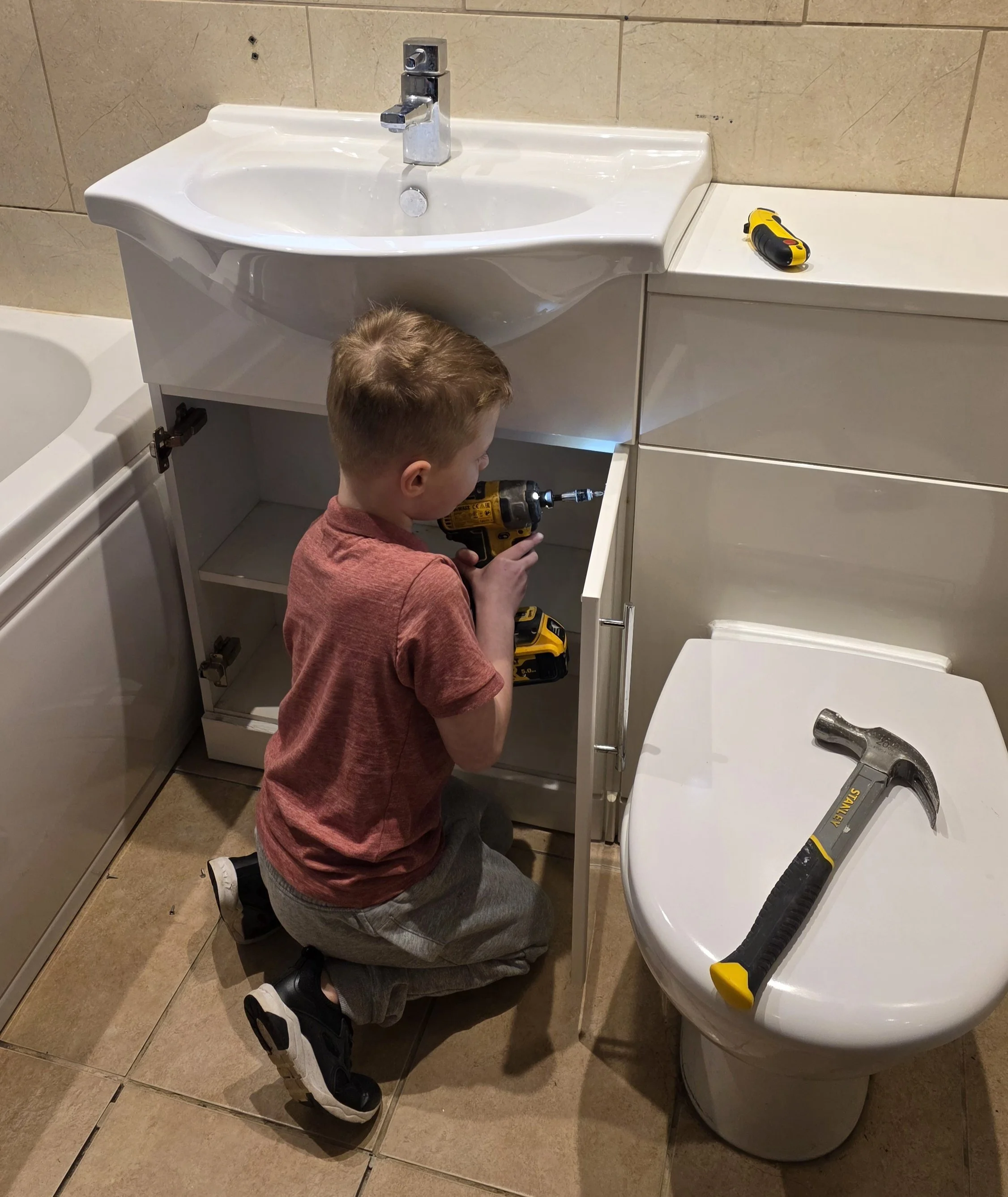 Oliver, son of Oliver Francis Interiors founders Mike and Jenny, helping with a bathroom vanity unit installation.