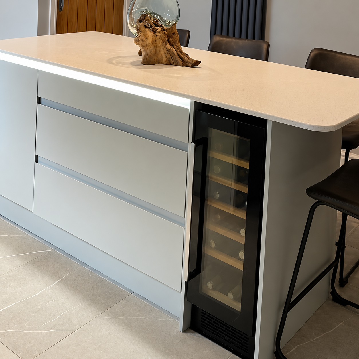Completed kitchen renovation by Oliver Francis Interiors featuring a breakfast bar with seating, pendant lights and integrated wine cooler.