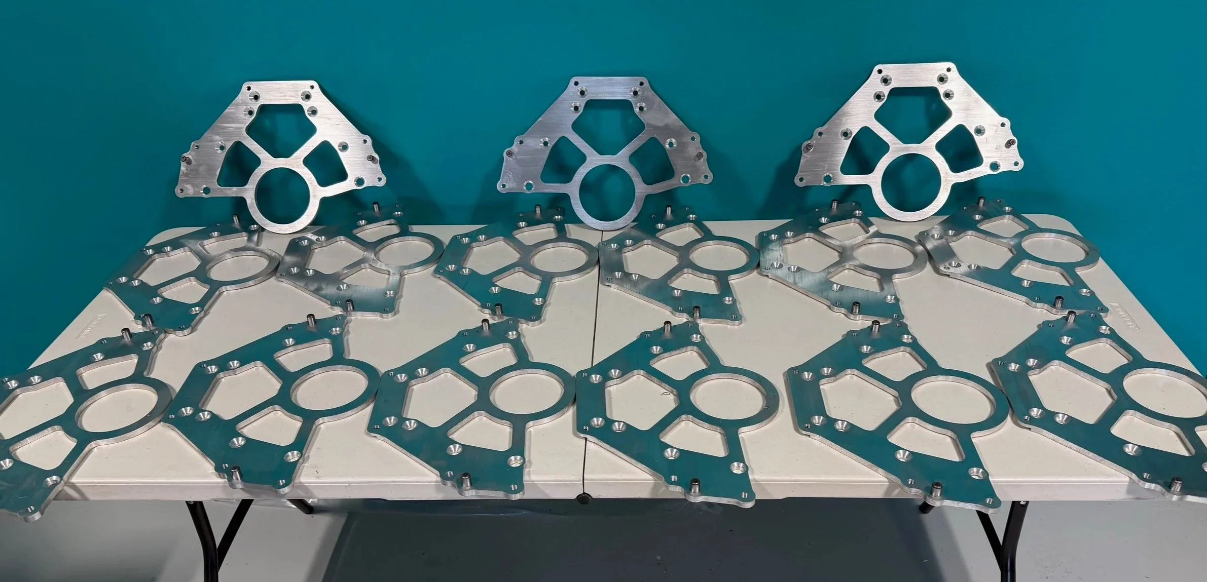 Table with 2.3L Ford to 5.0L Ford bellhousing adapter plates.