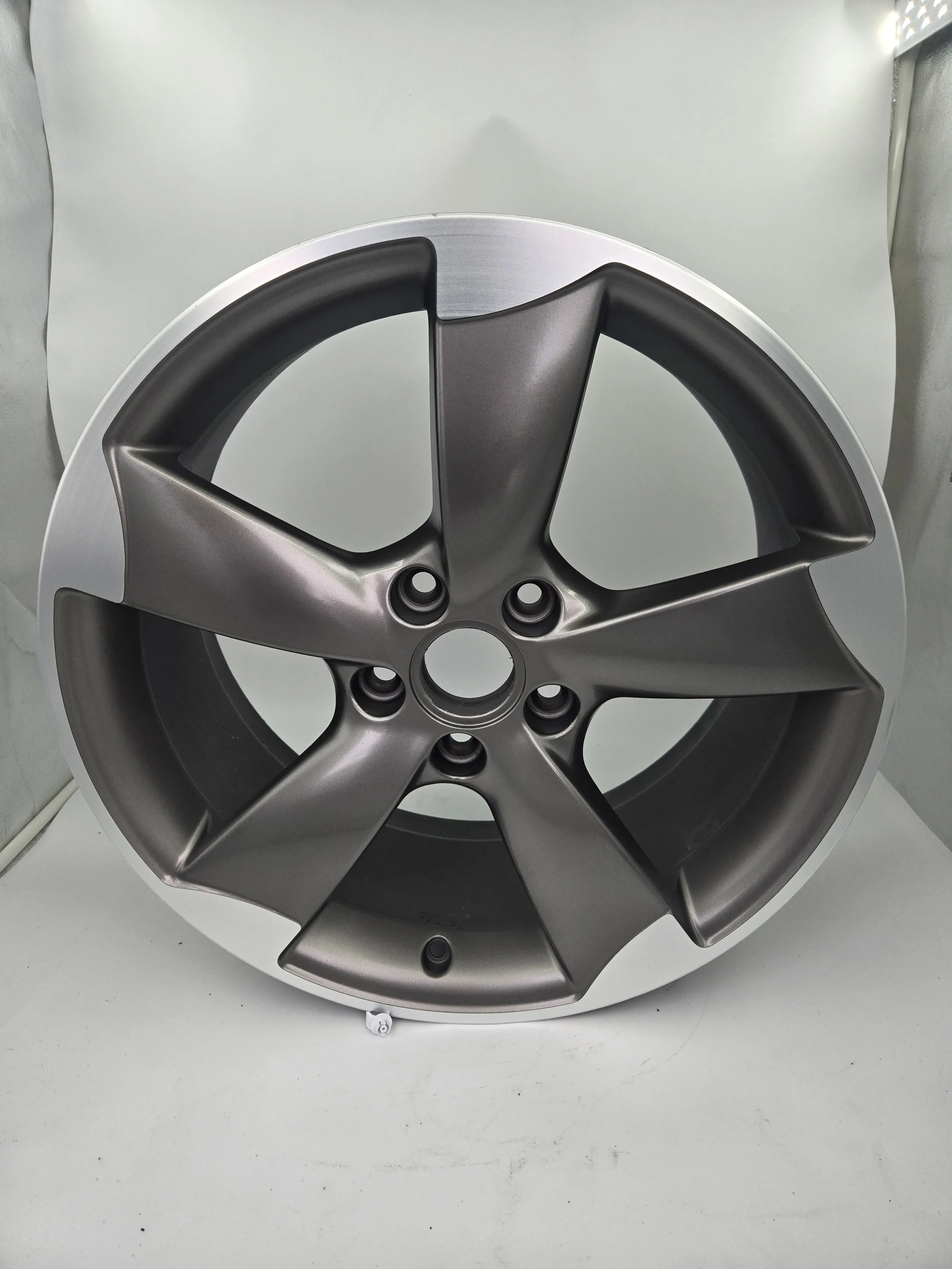 A metallic alloy wheel rim with five spokes, placed against a plain white background.