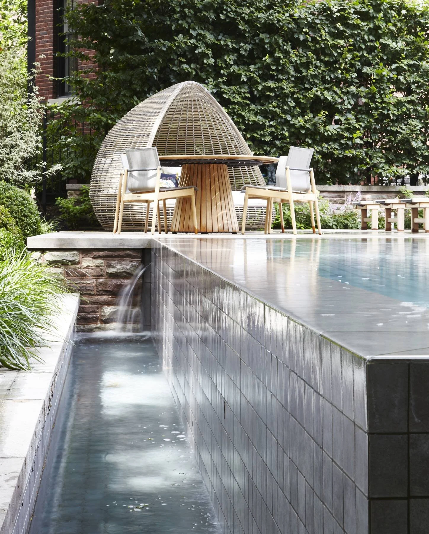 Pool with a vanishing edge and a garden pavilion beyond