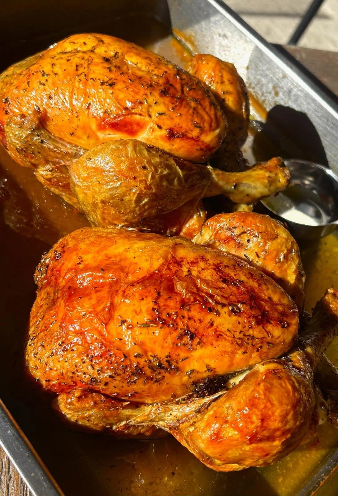 Poulet rôti doré dans une plaque, accompagné de sauce